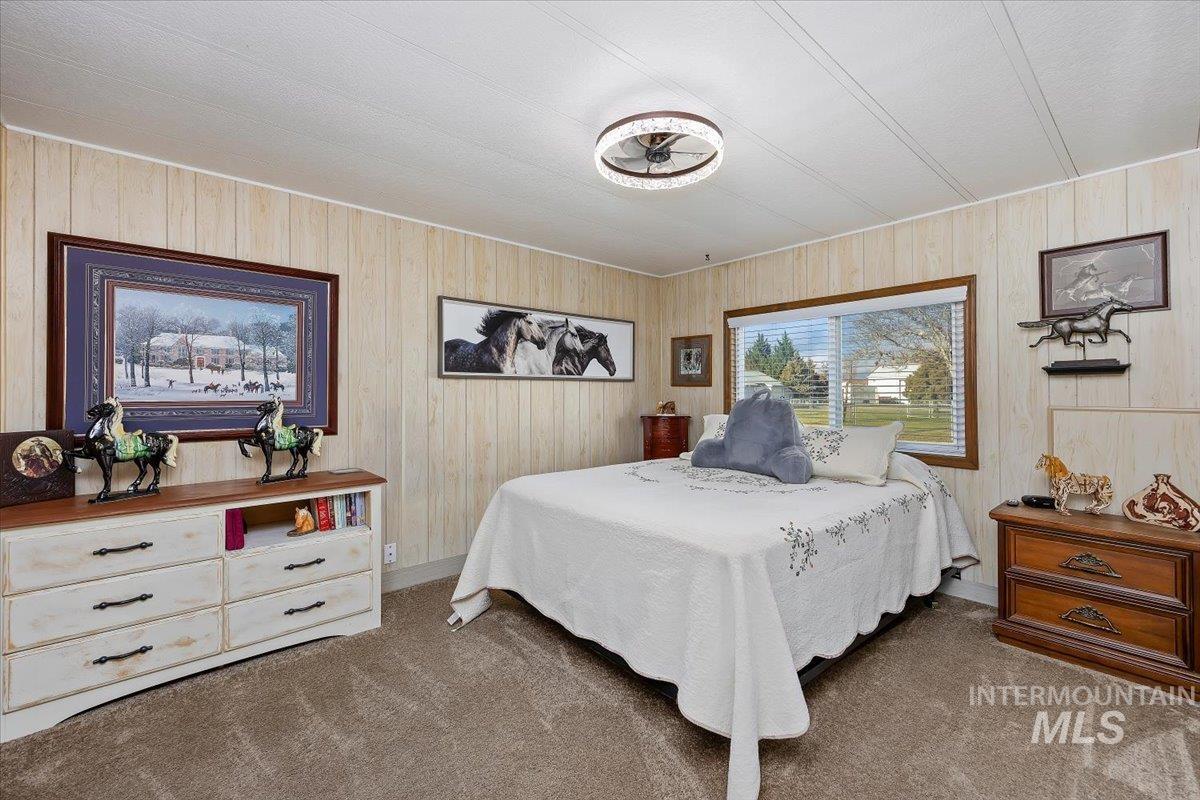 Carpeted bedroom with wood walls