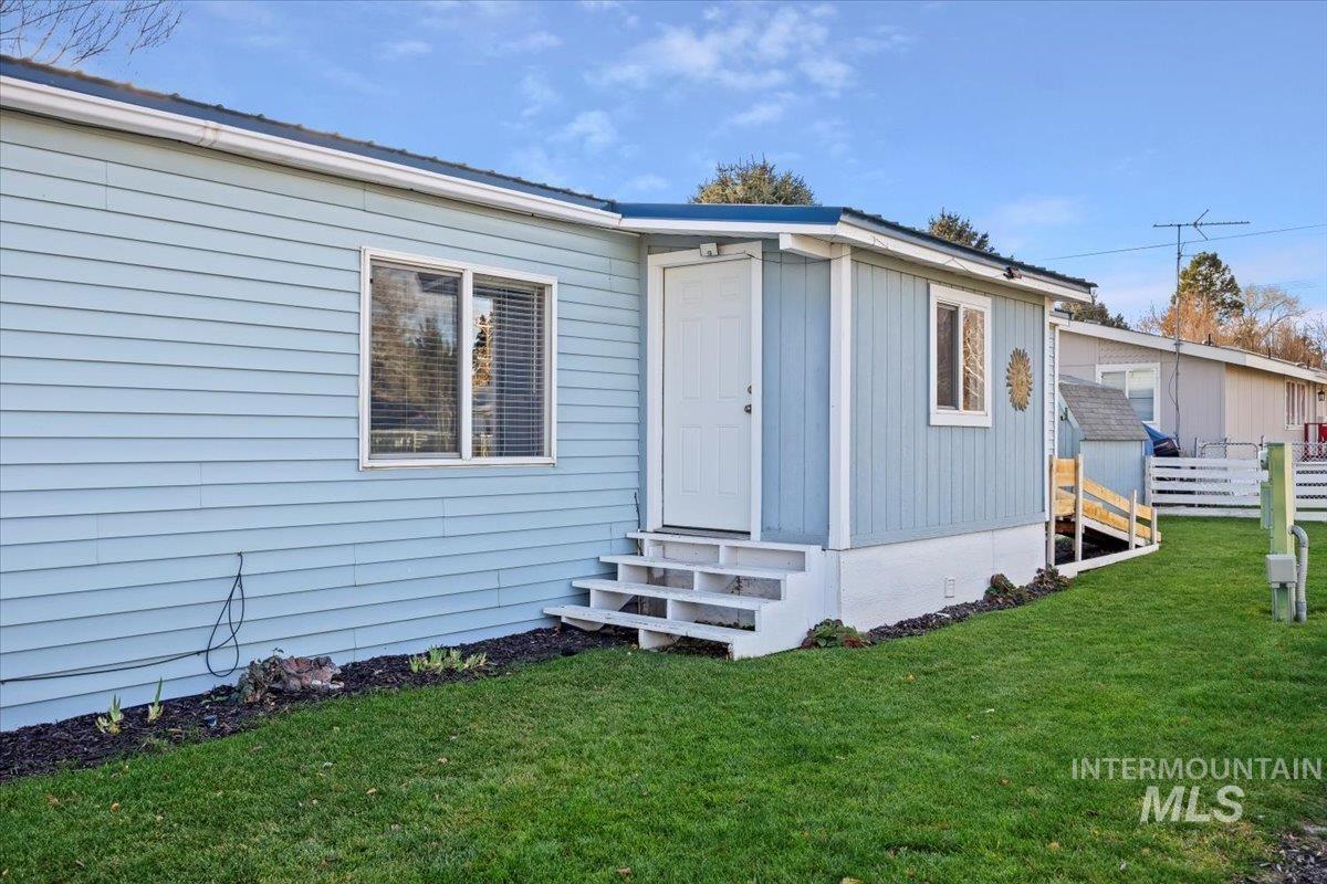 Doorway to property with a lawn