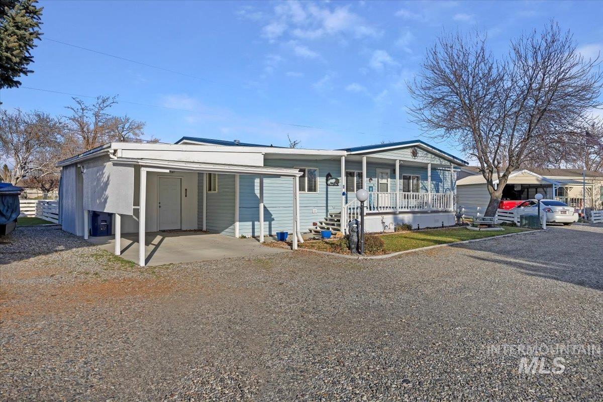 View of front of property featuring covered porch, an attached carport, and driveway