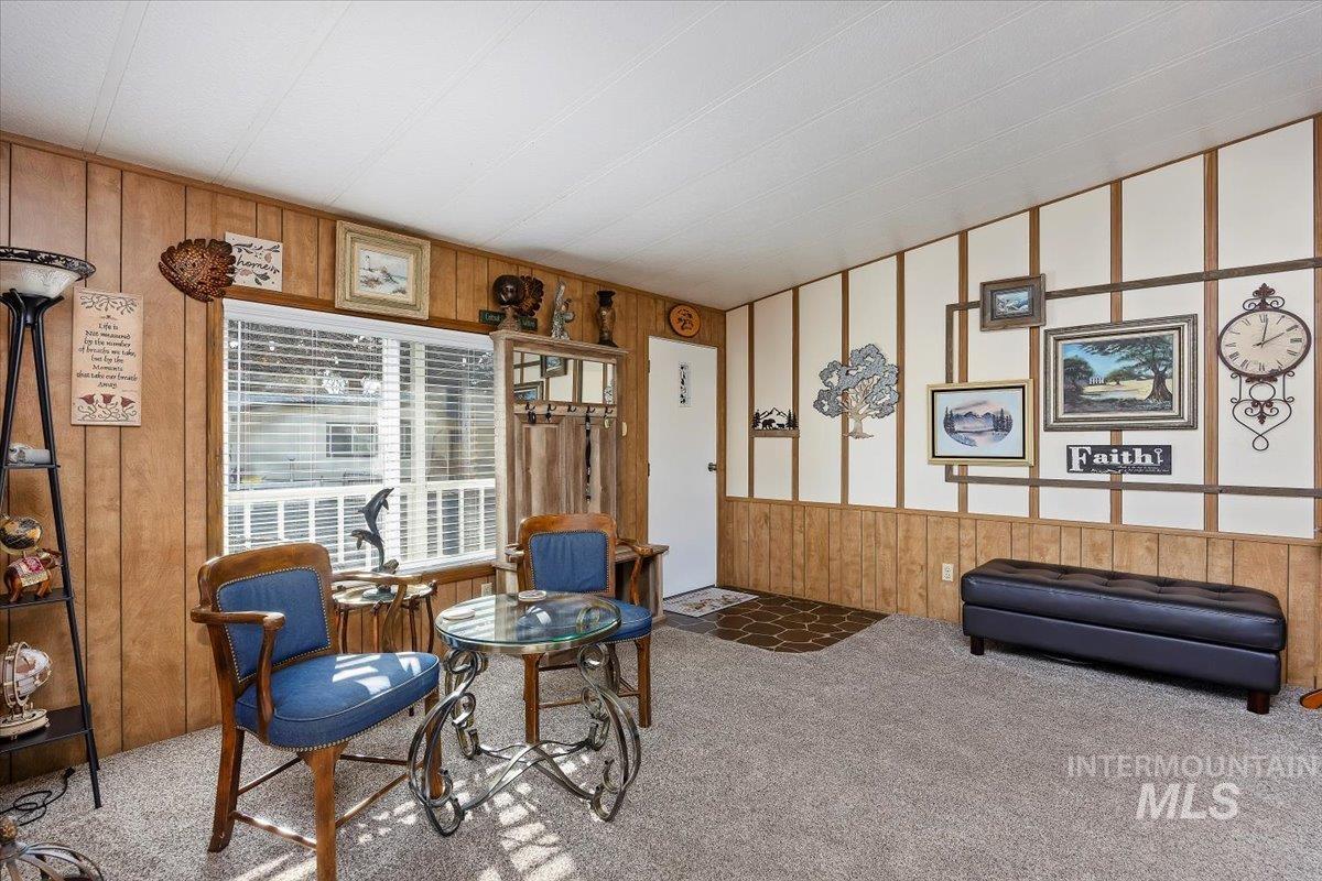 Living area featuring wood walls and carpet