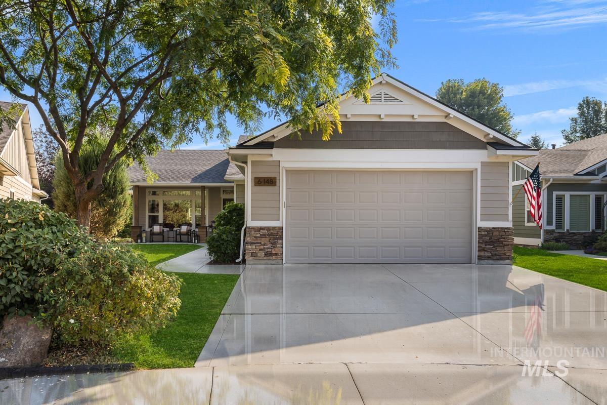 Craftsman-style home with stone siding, concrete driveway, a garage, and roof with shingles