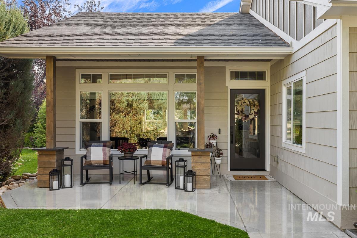 Property entrance featuring roof with shingles and a patio area