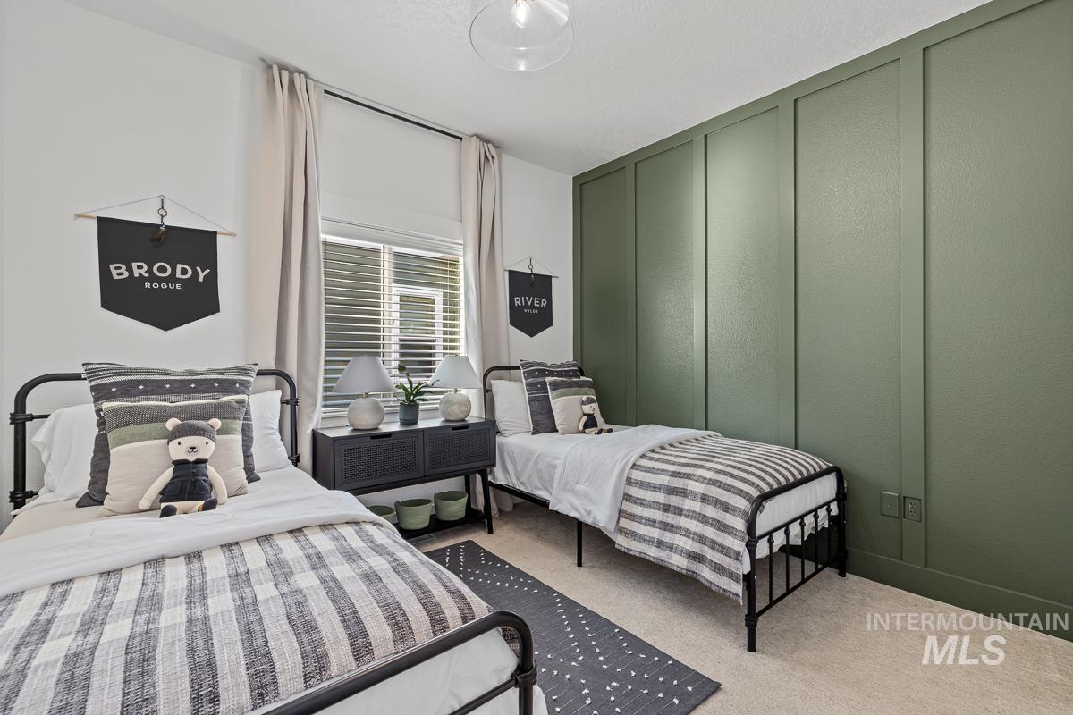 Carpeted bedroom with a decorative wall