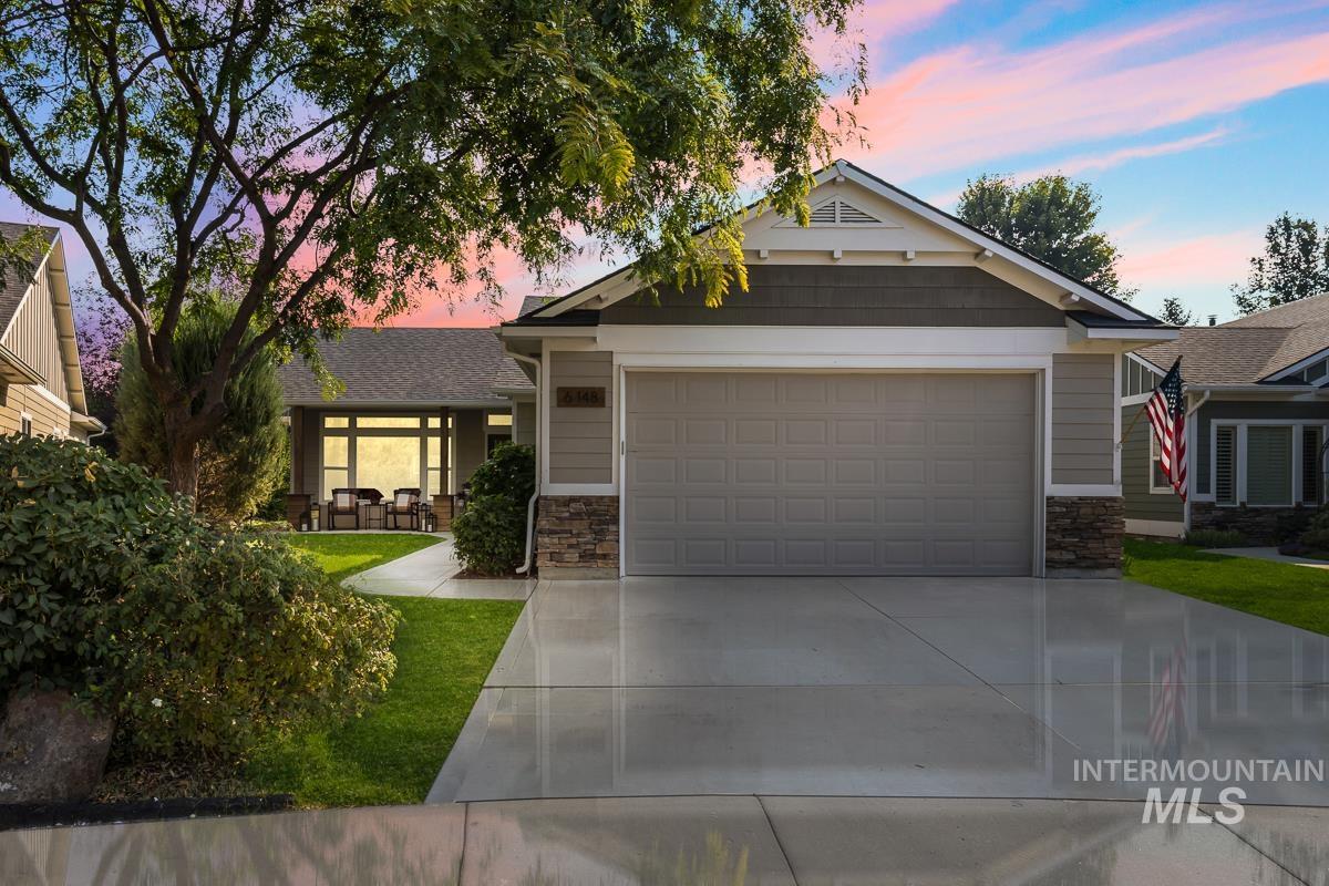 Craftsman-style home with stone siding, driveway, and an attached garage