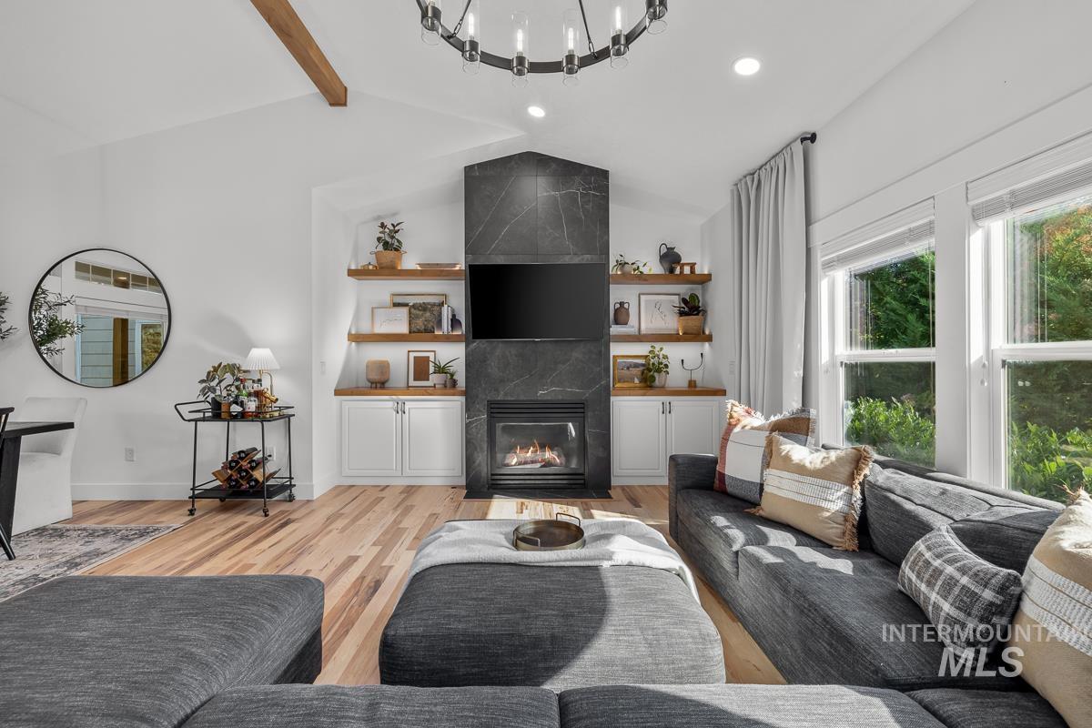 Living room with a tiled fireplace, light wood-type flooring, and recessed lighting