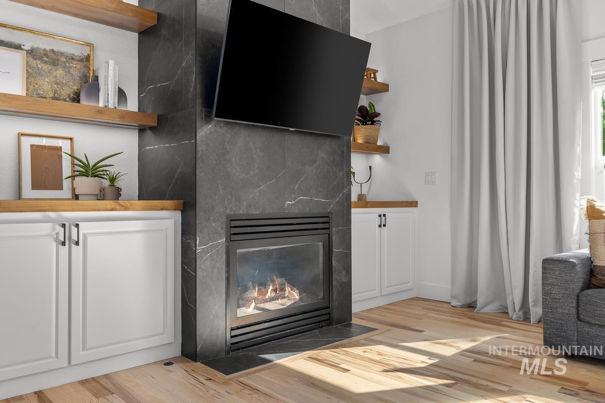 Detailed view of wood finished floors and a large fireplace