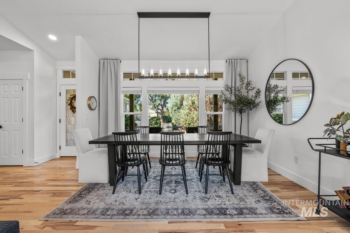 Dining area with light wood-style floors and recessed lighting