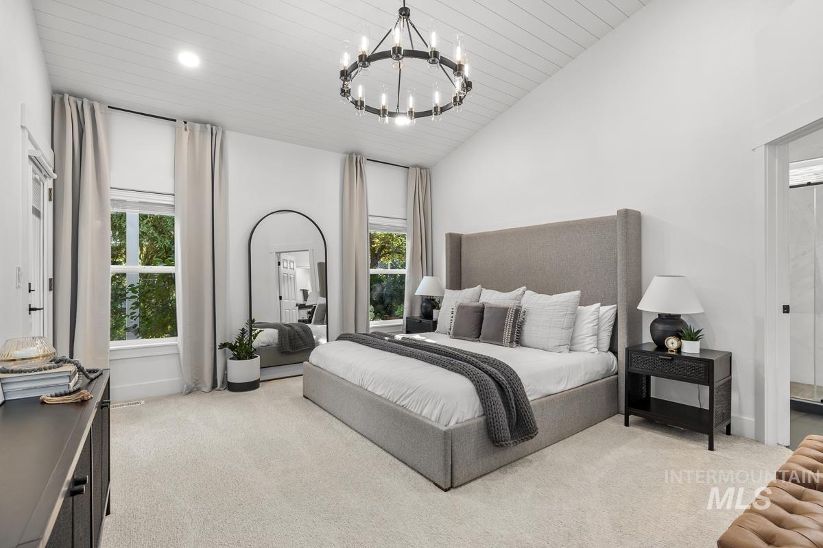 Bedroom with wood ceiling, light carpet, a chandelier, and high vaulted ceiling