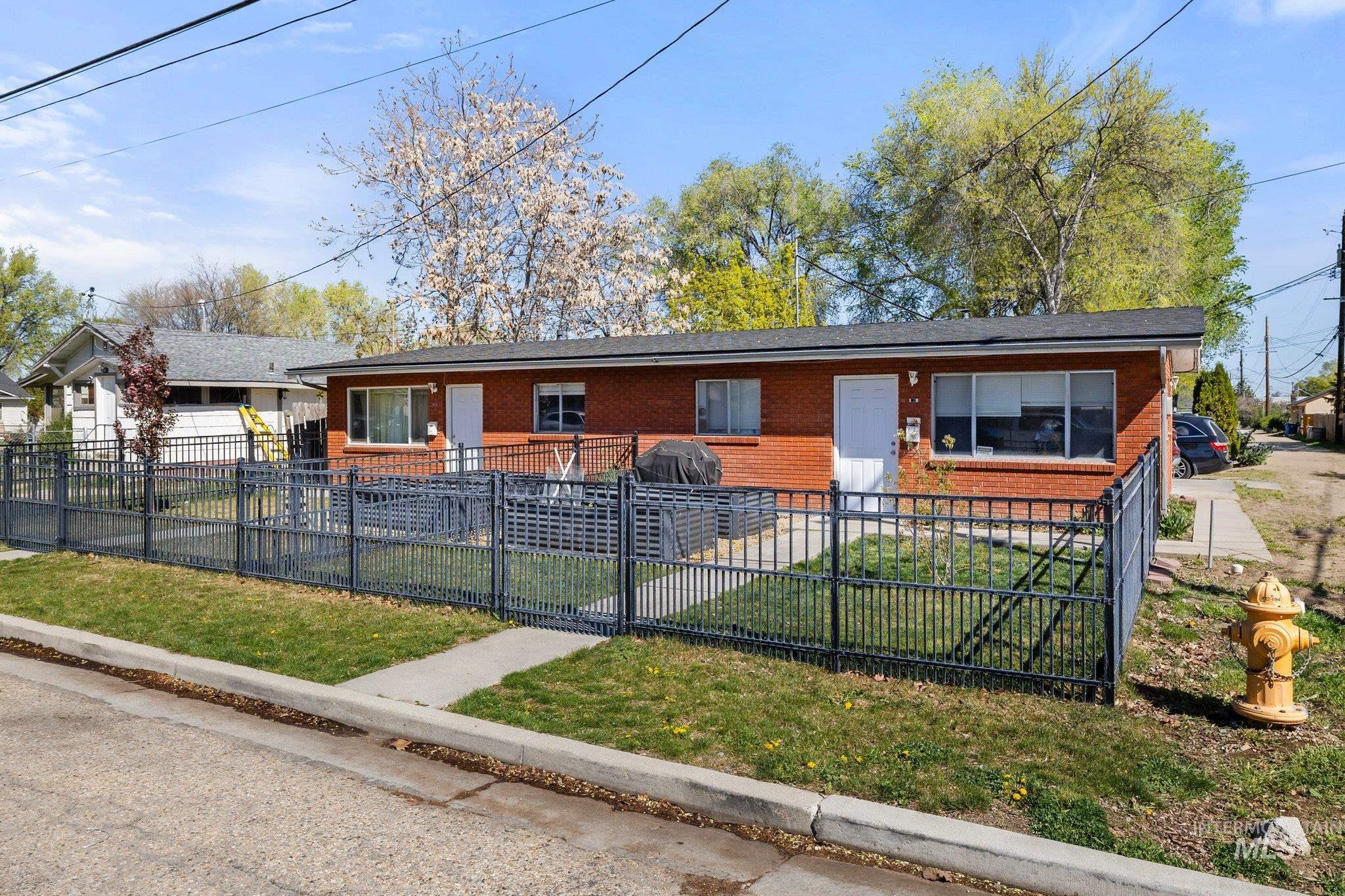 View of front facade featuring brick siding, a fenced front yard, and a gate