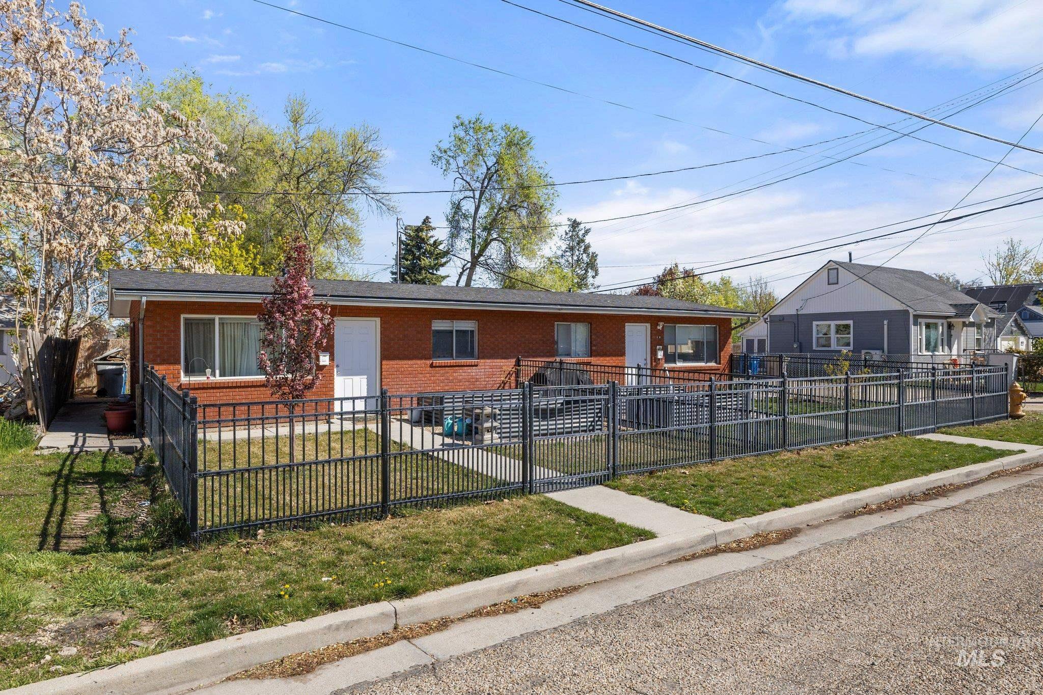 View of front of property with brick siding and a fenced front yard