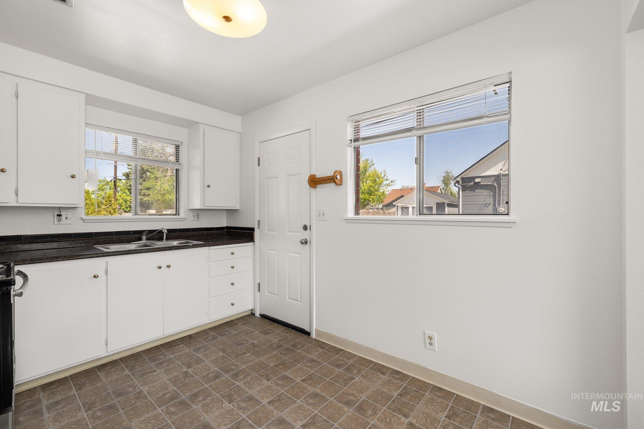 Kitchen with white cabinets and plenty of natural light