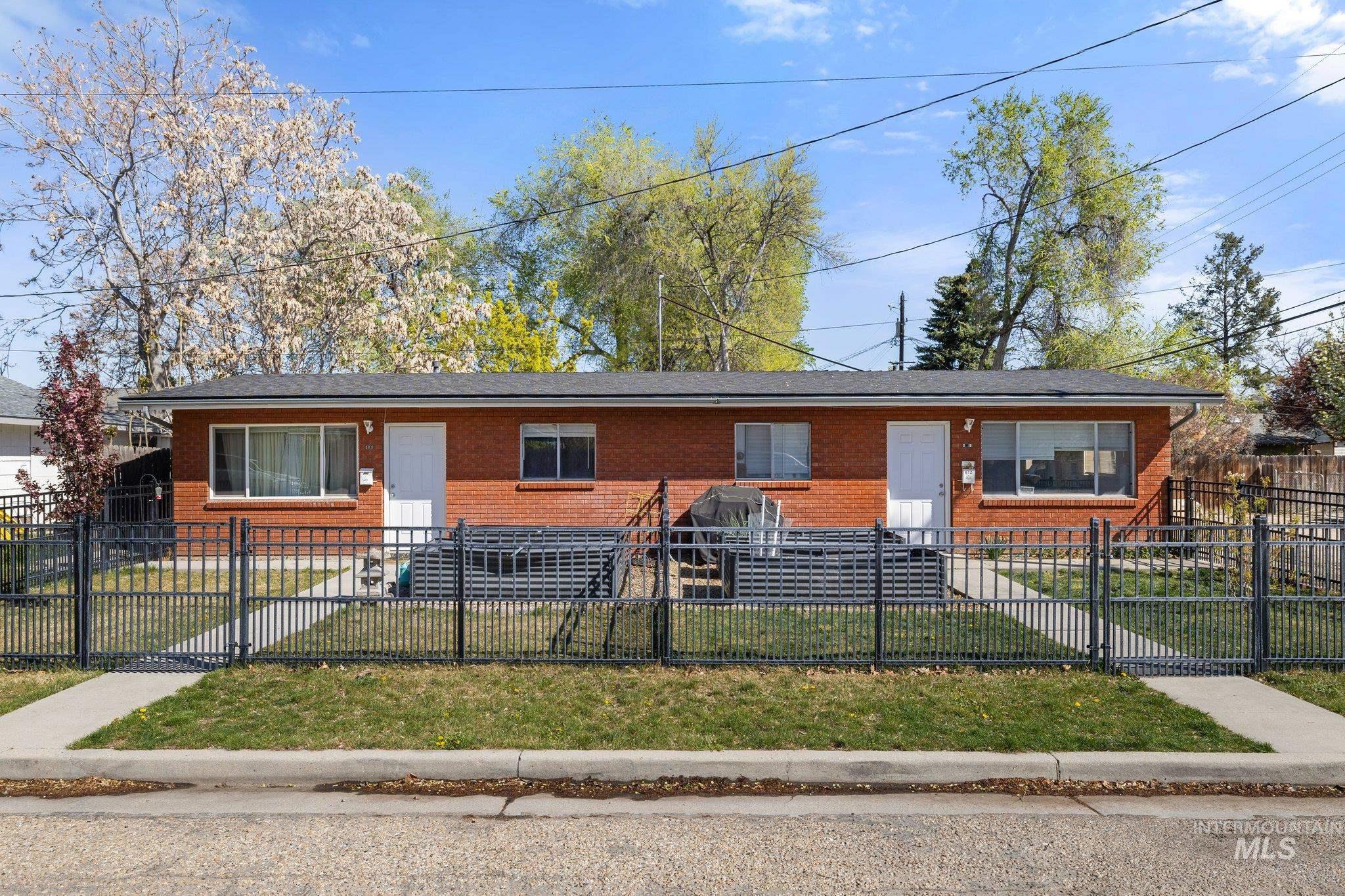 View of front facade with brick siding and a fenced front yard