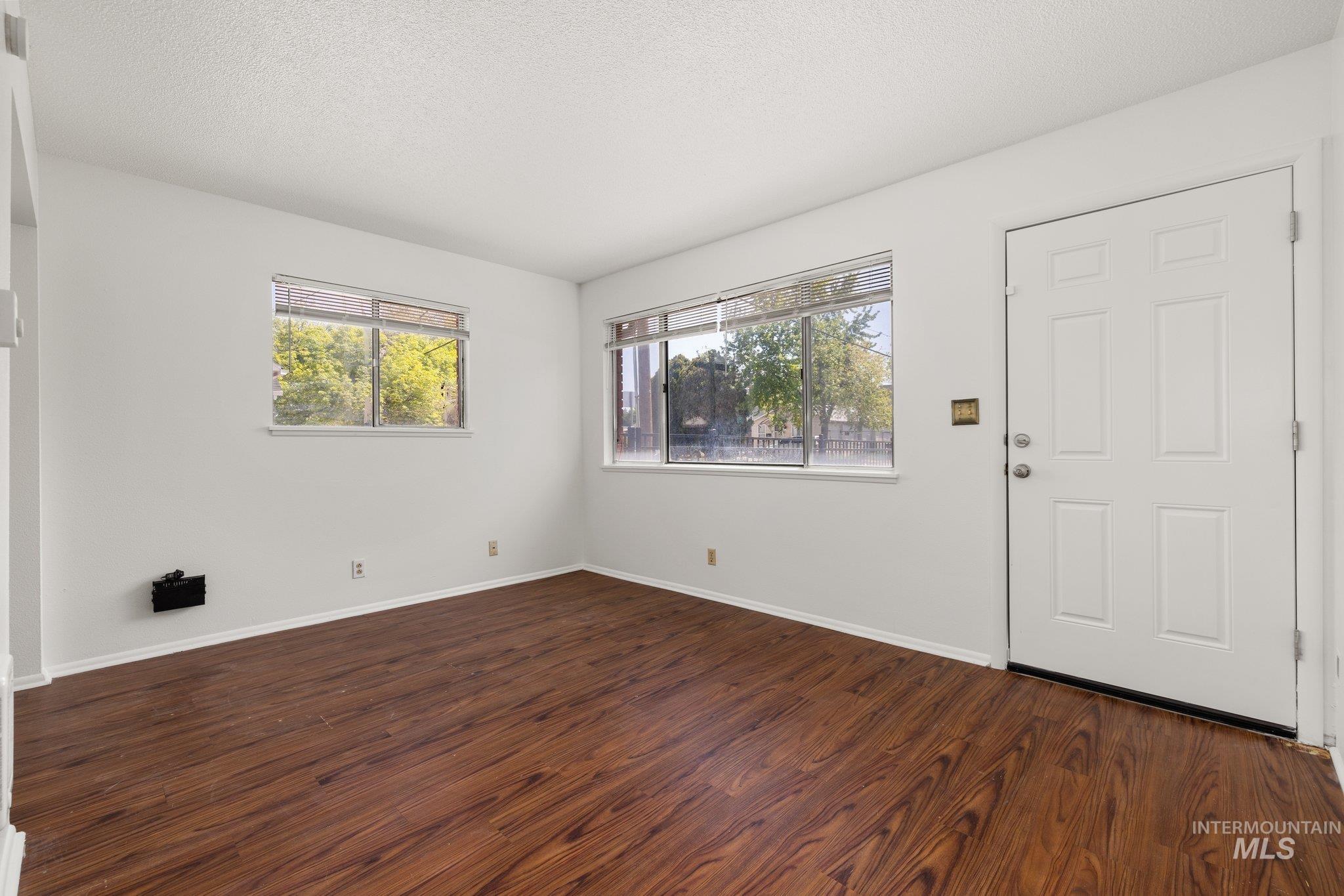 Foyer entrance featuring dark wood finished floors and a textured ceiling