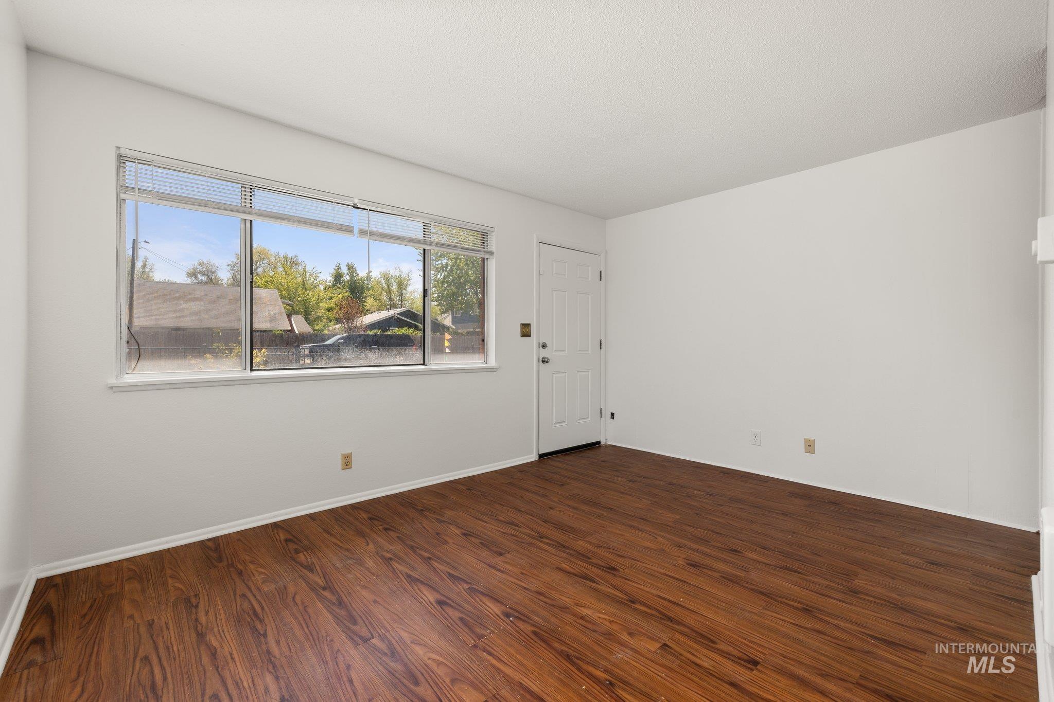 Unfurnished room with dark wood-style floors and baseboards