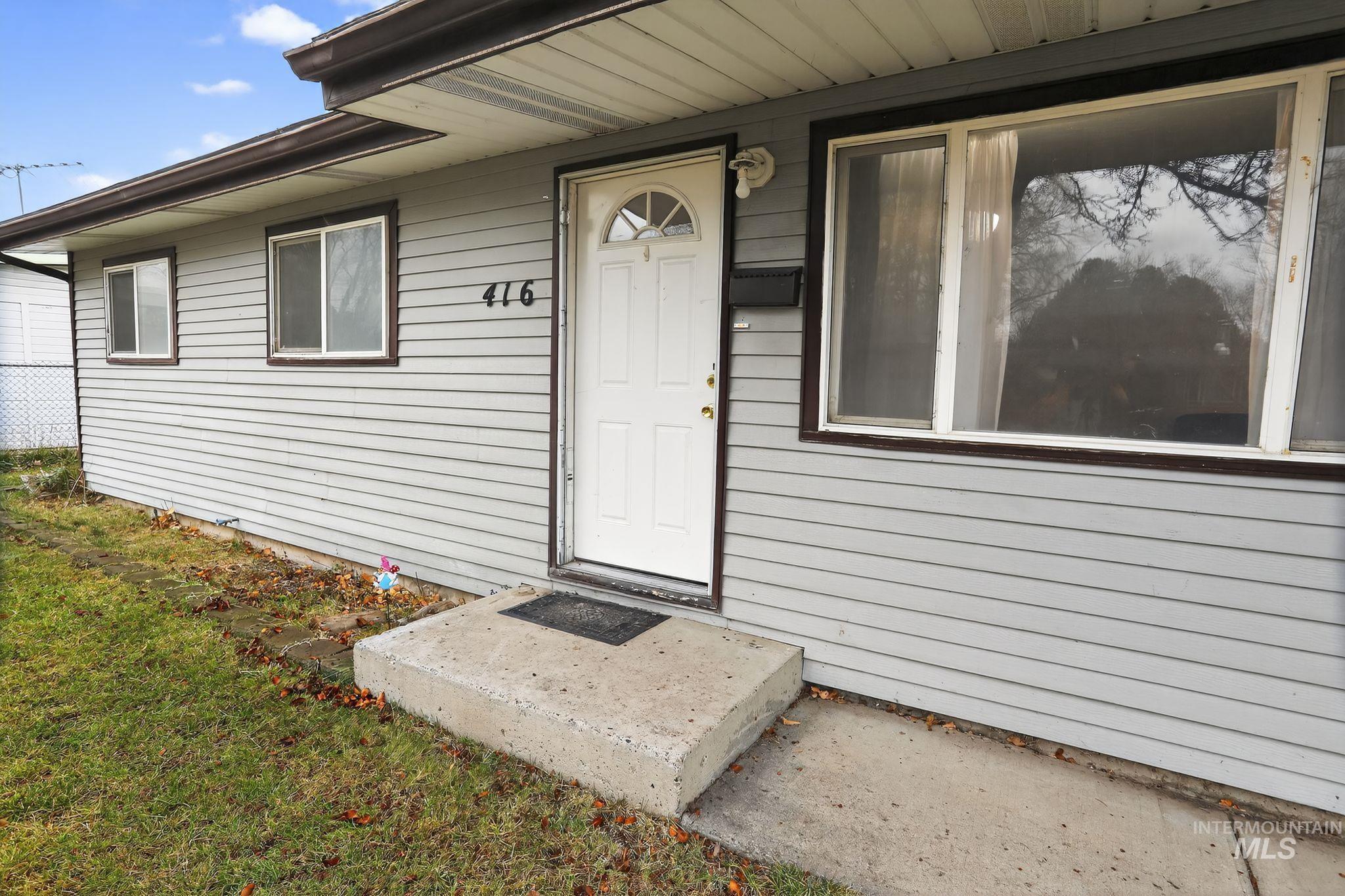 View of exterior entry with a yard