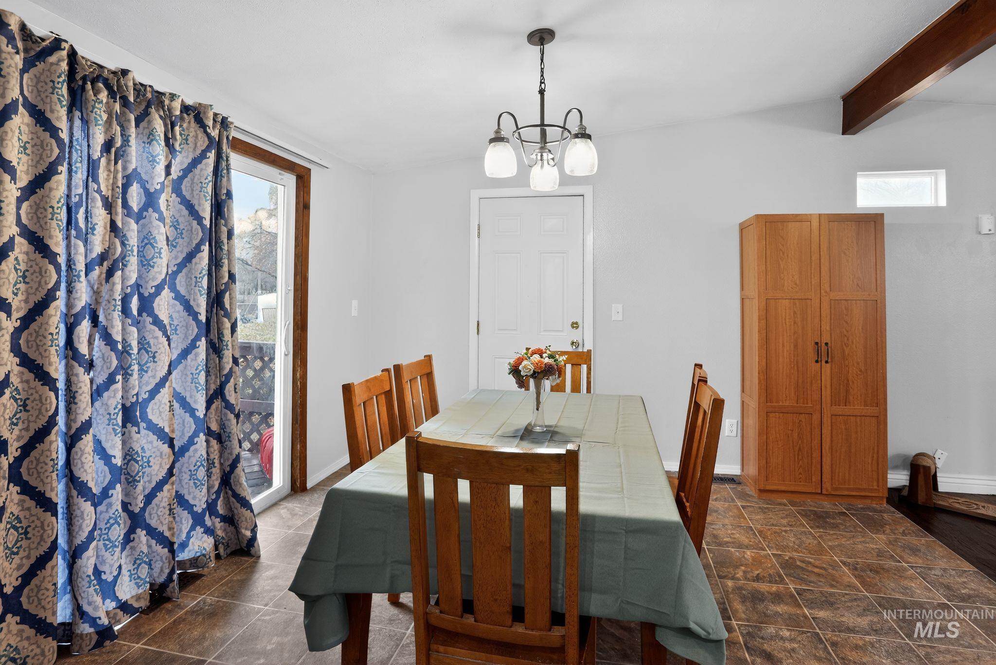 Dining room with beamed ceiling and a chandelier