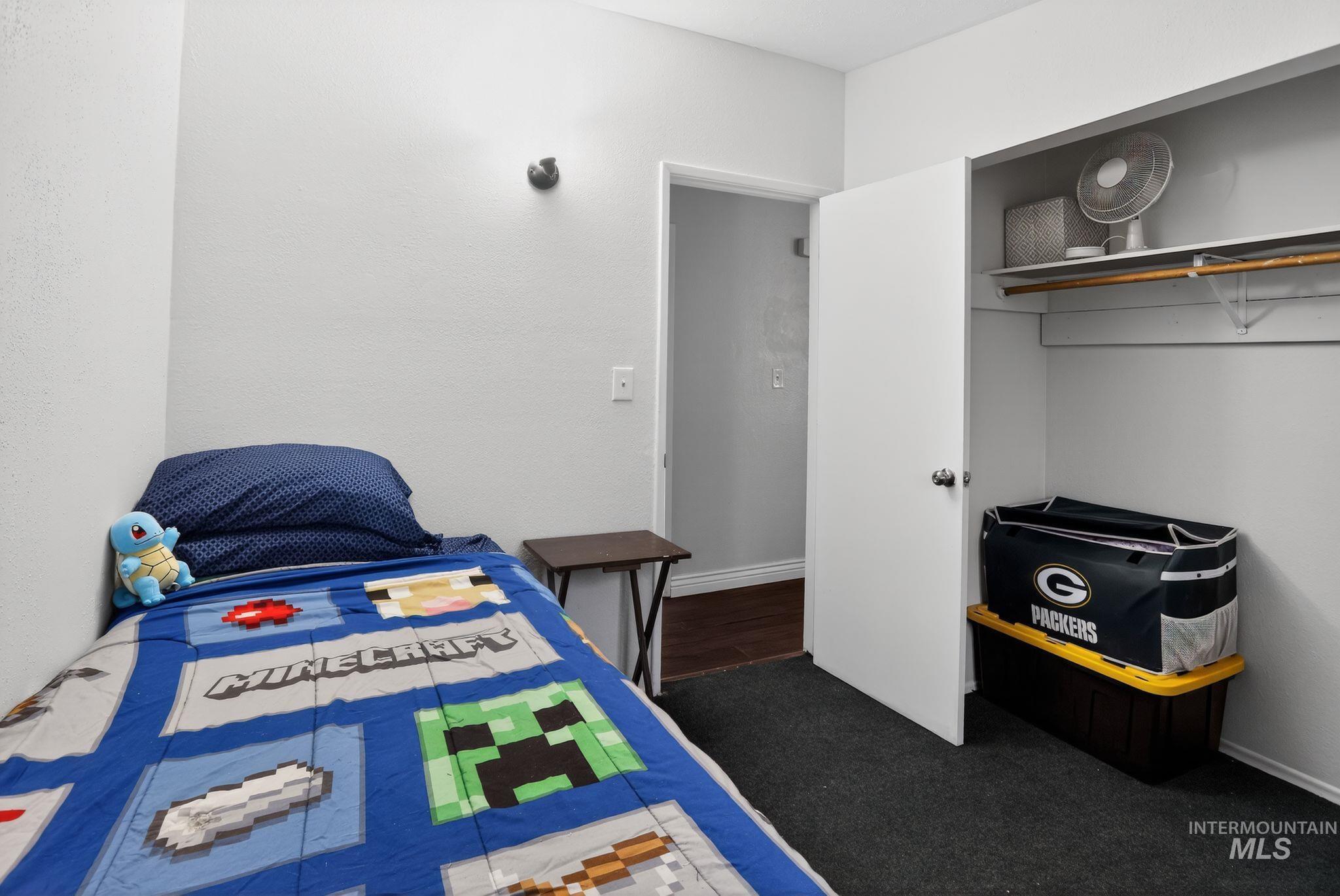Bedroom featuring baseboards and dark colored carpet