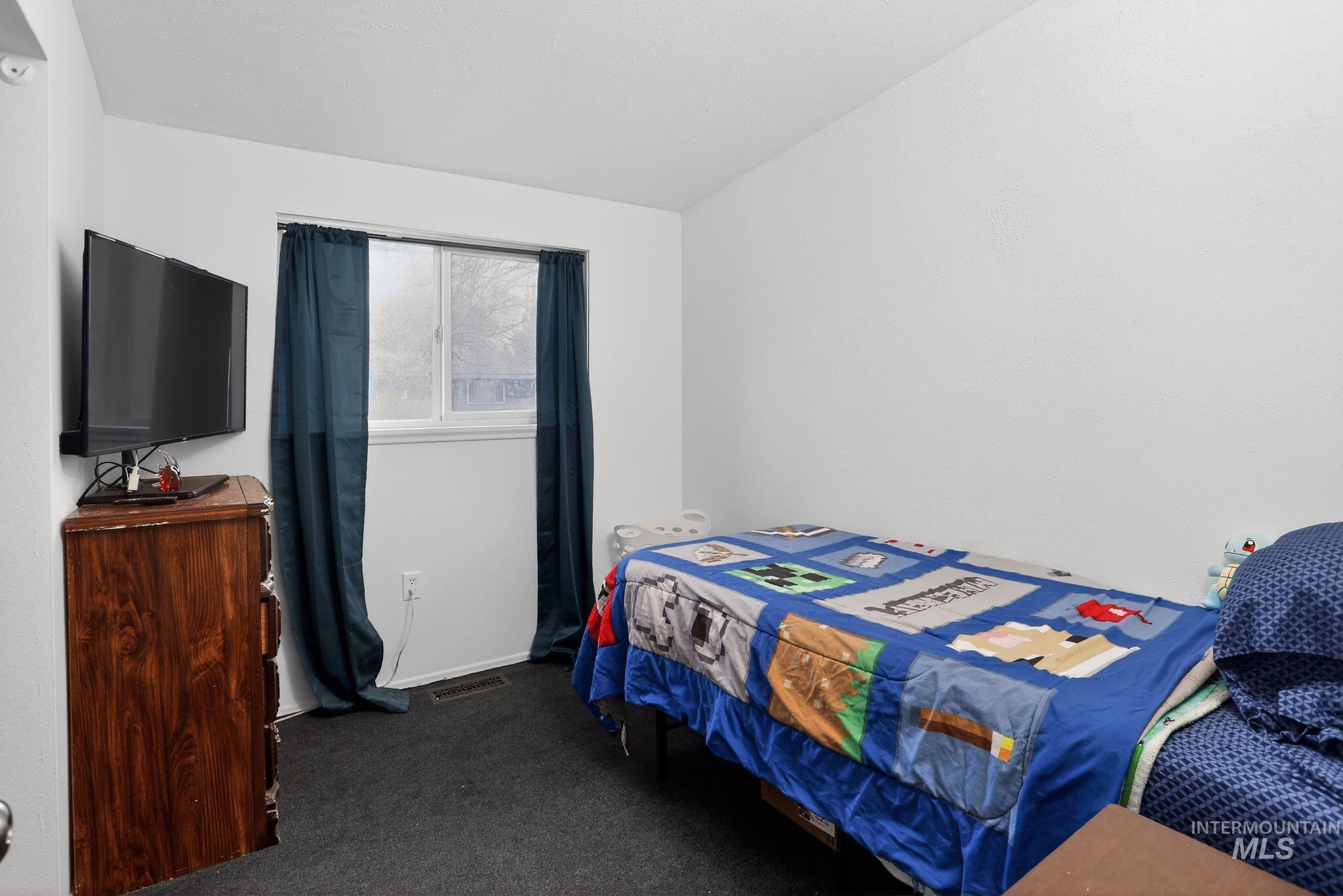 Bedroom featuring dark carpet