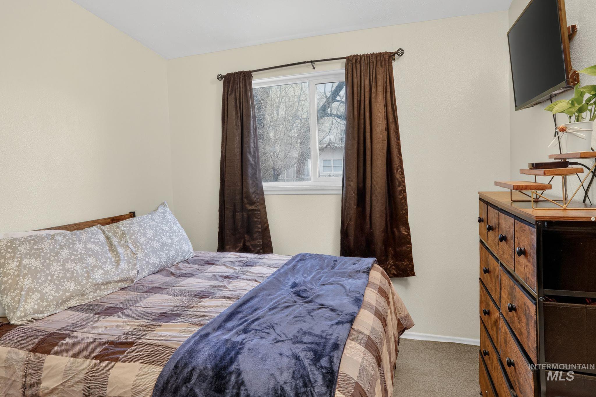 Bedroom featuring light colored carpet and baseboards