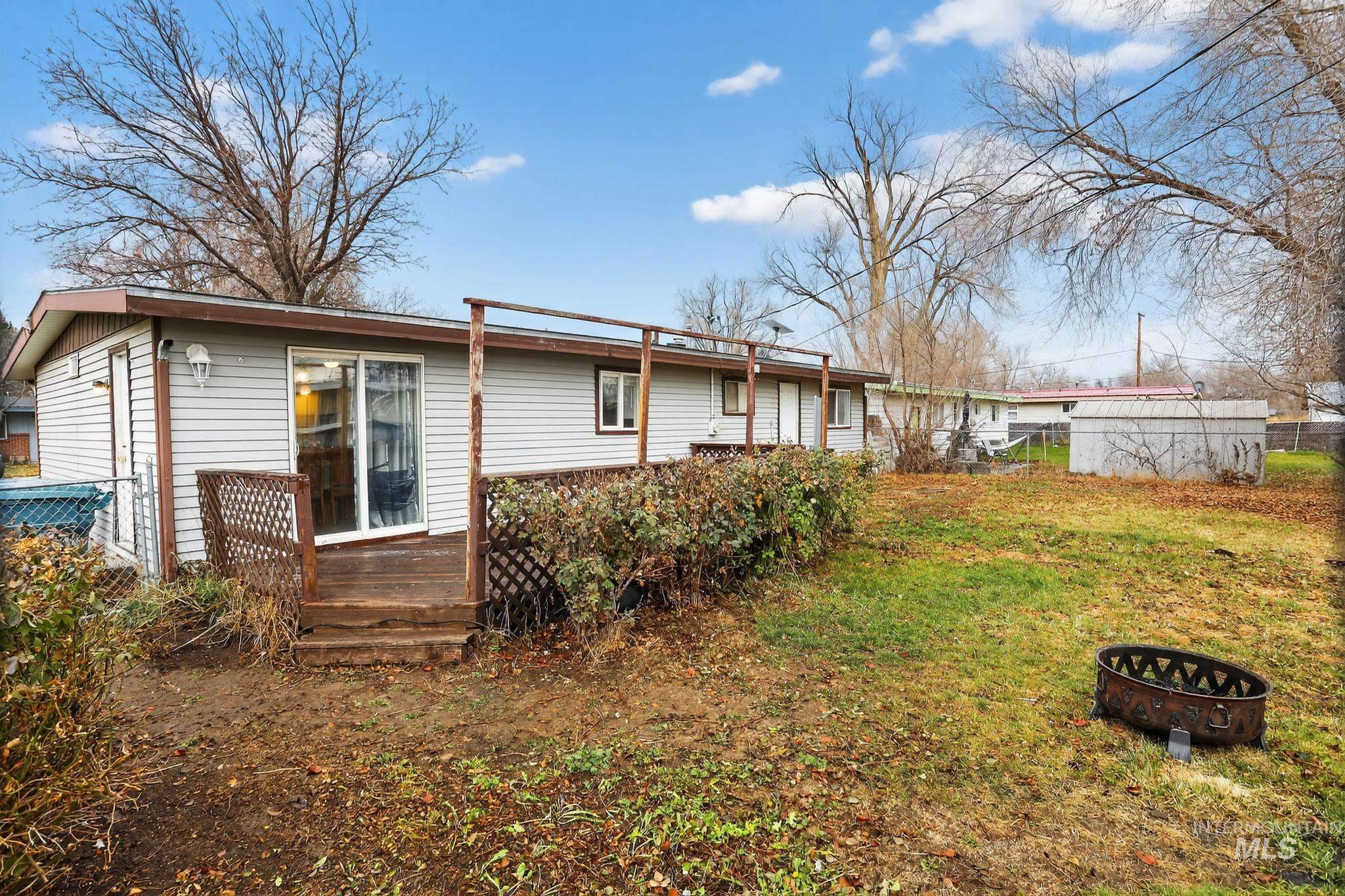Back of property featuring a deck and a fire pit