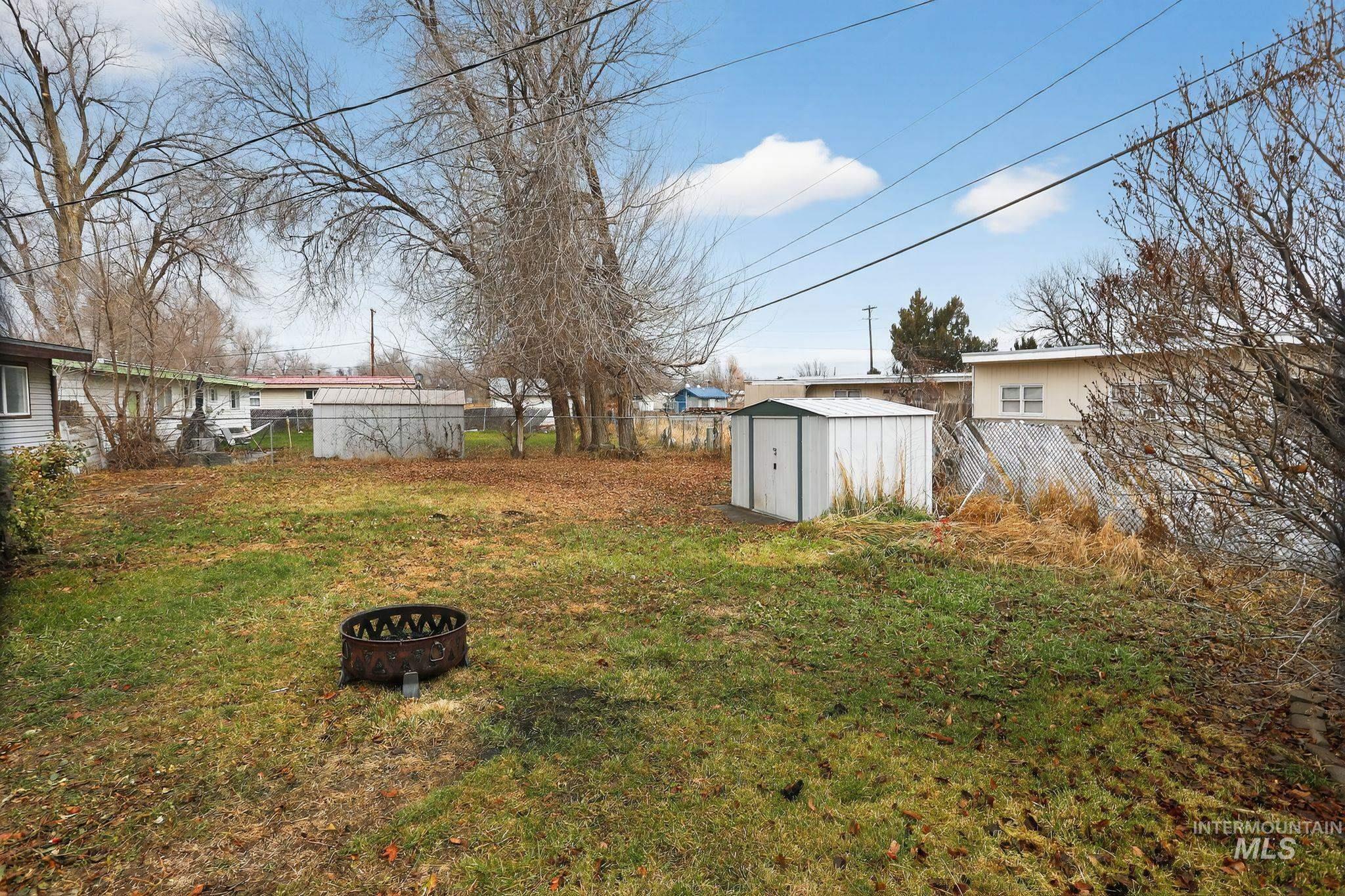 View of yard featuring a storage unit and an outdoor fire pit