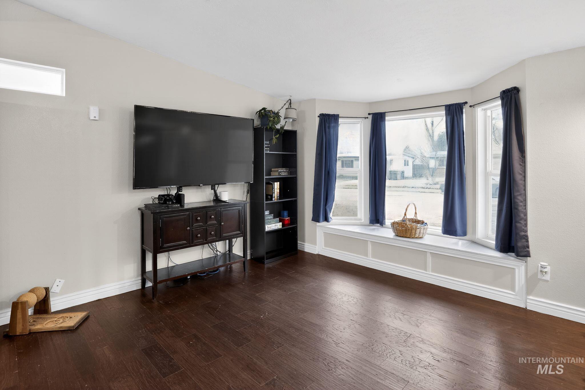 Living room with plenty of natural light and dark wood-style floors