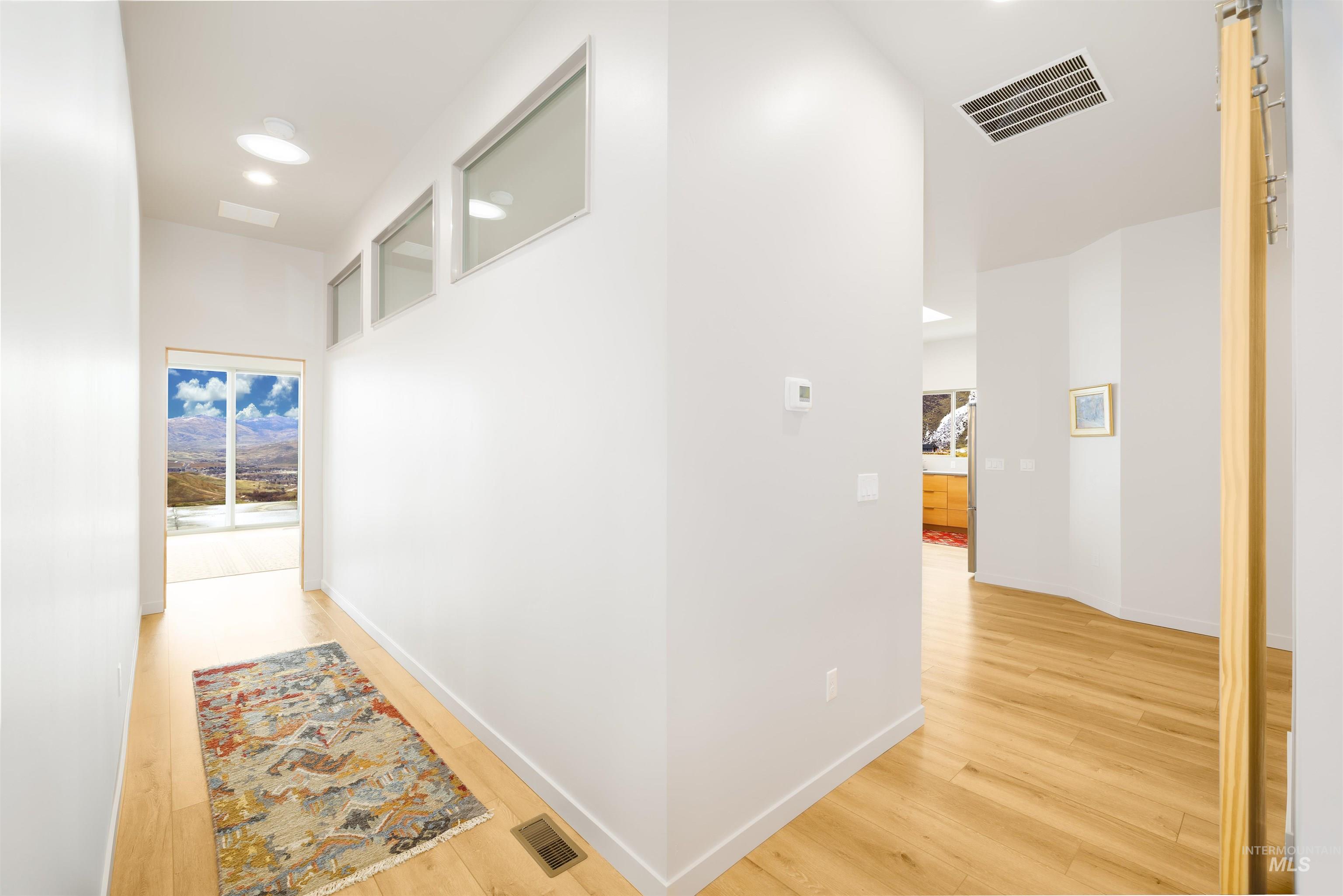 Corridor featuring light wood finished floors and recessed lighting
