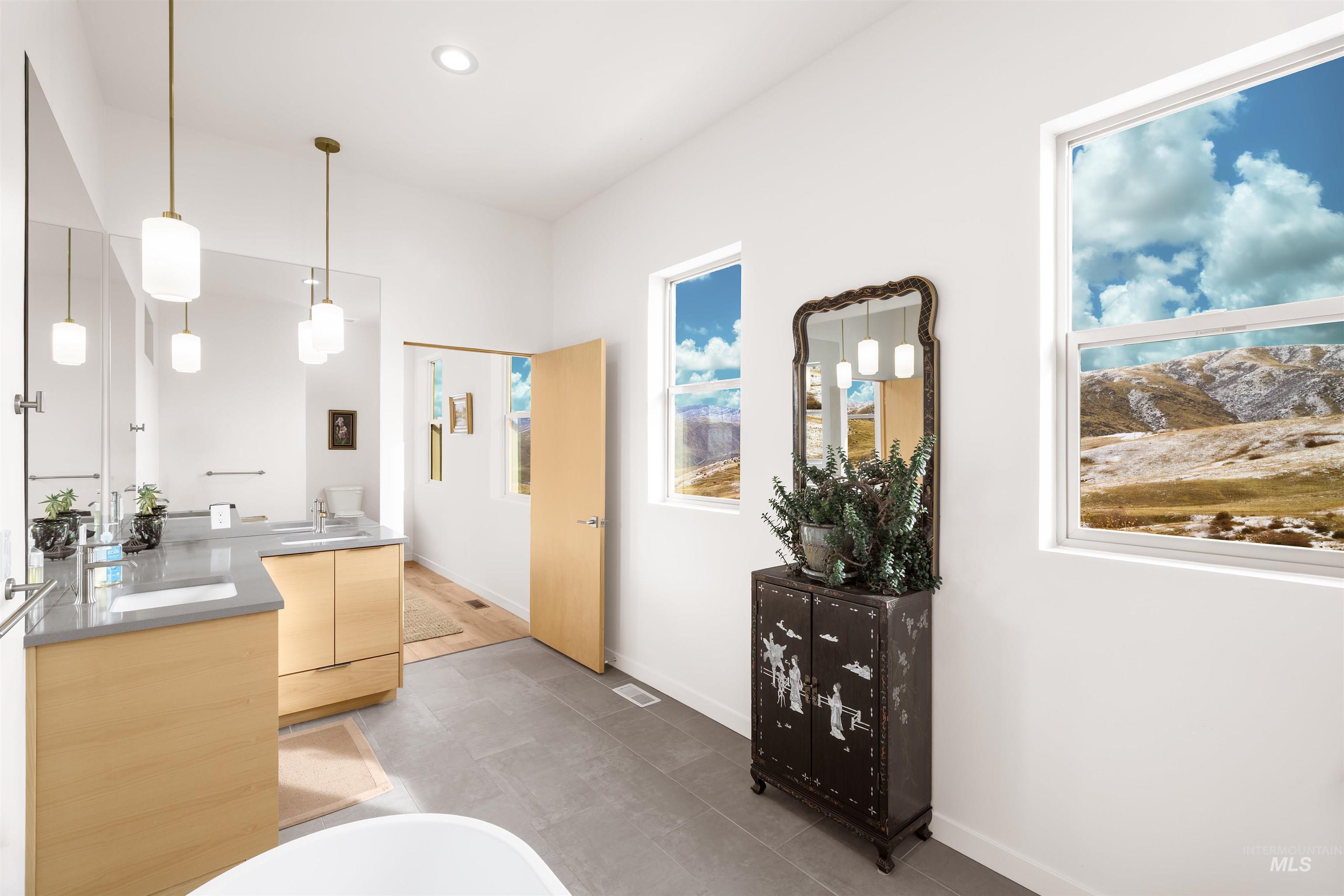 Full bath featuring double vanity, a freestanding tub, and recessed lighting
