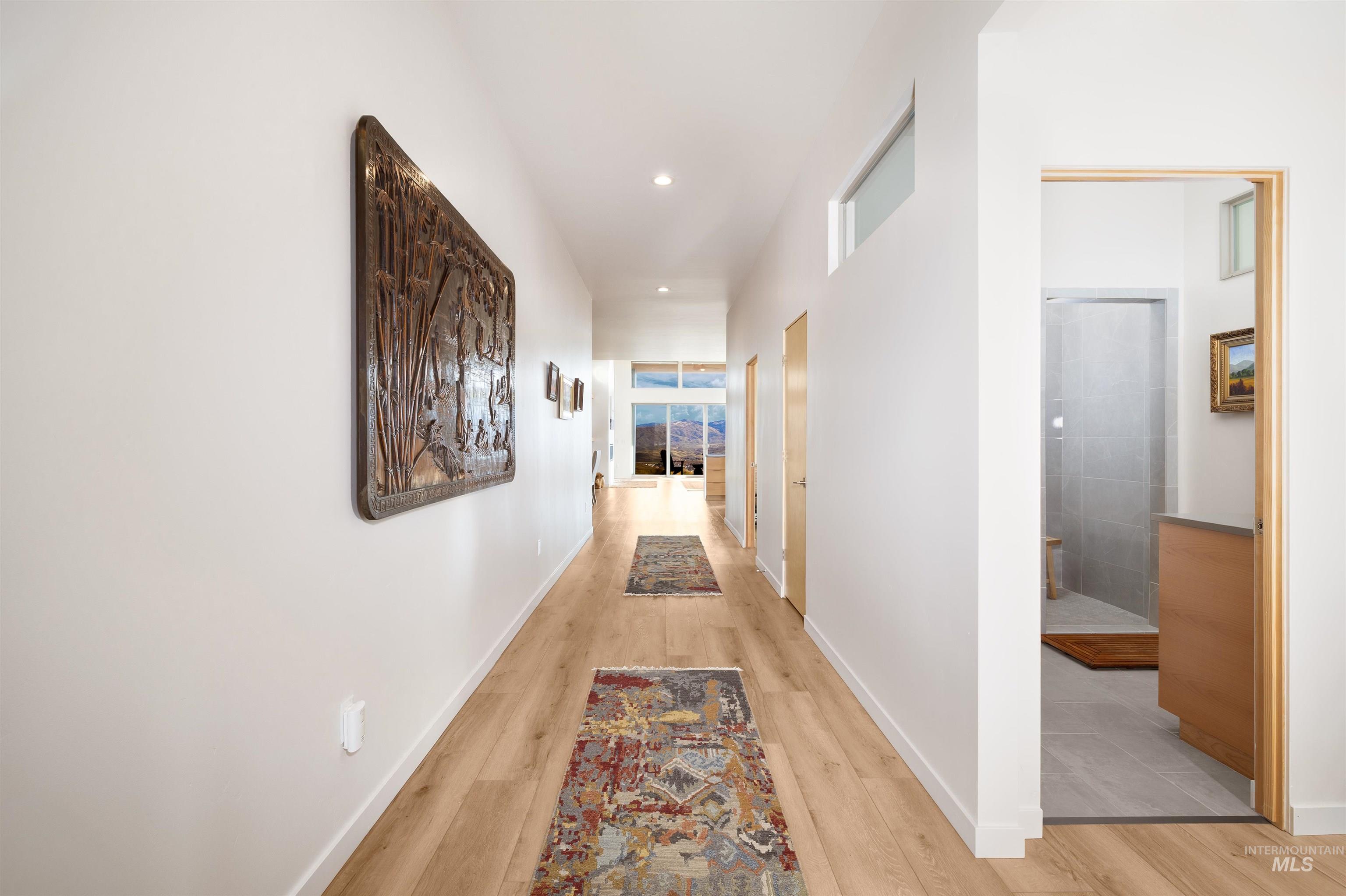 Corridor featuring light wood finished floors and recessed lighting