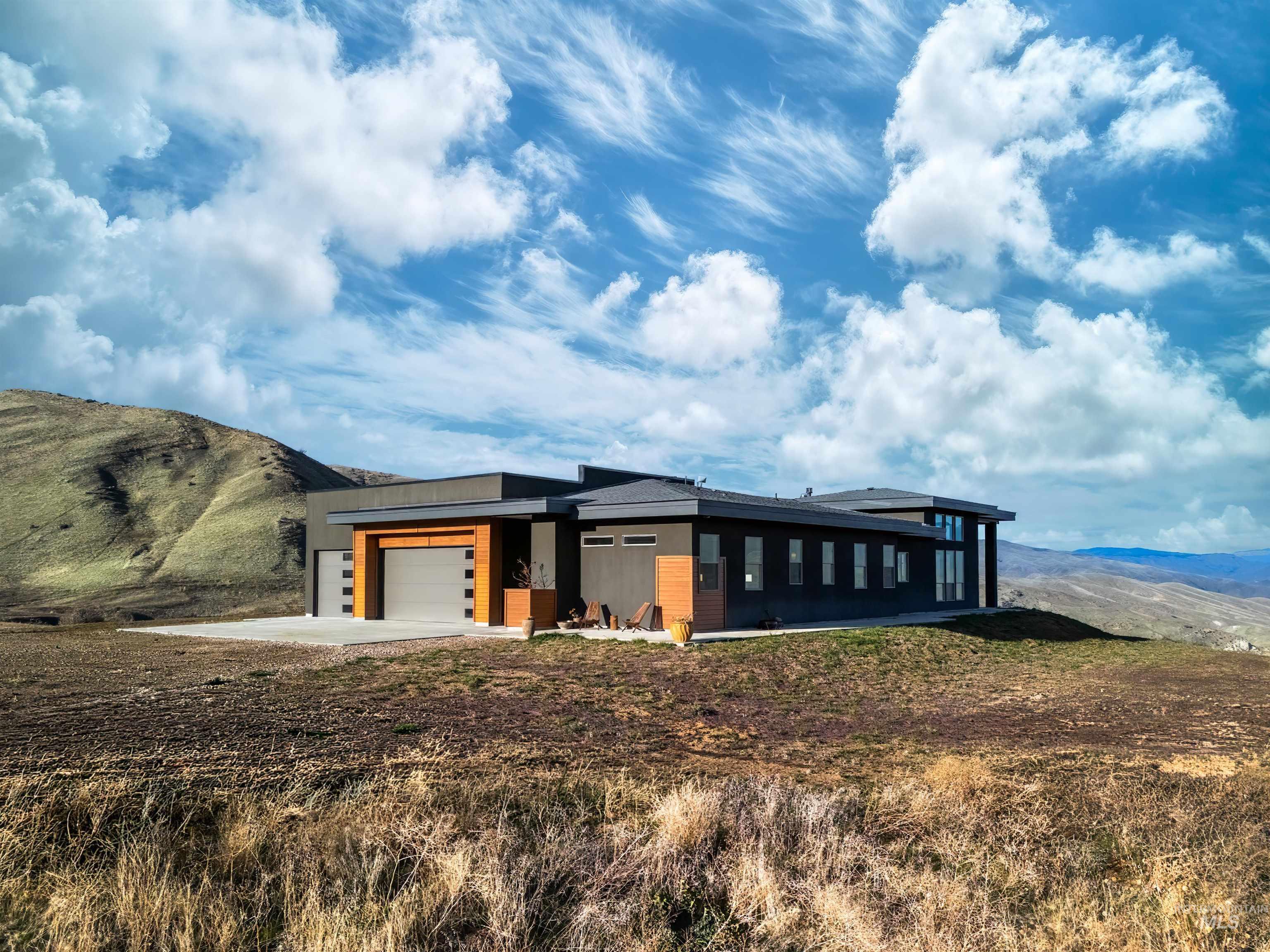 View of front of house featuring a mountain view, an attached garage, and concrete driveway