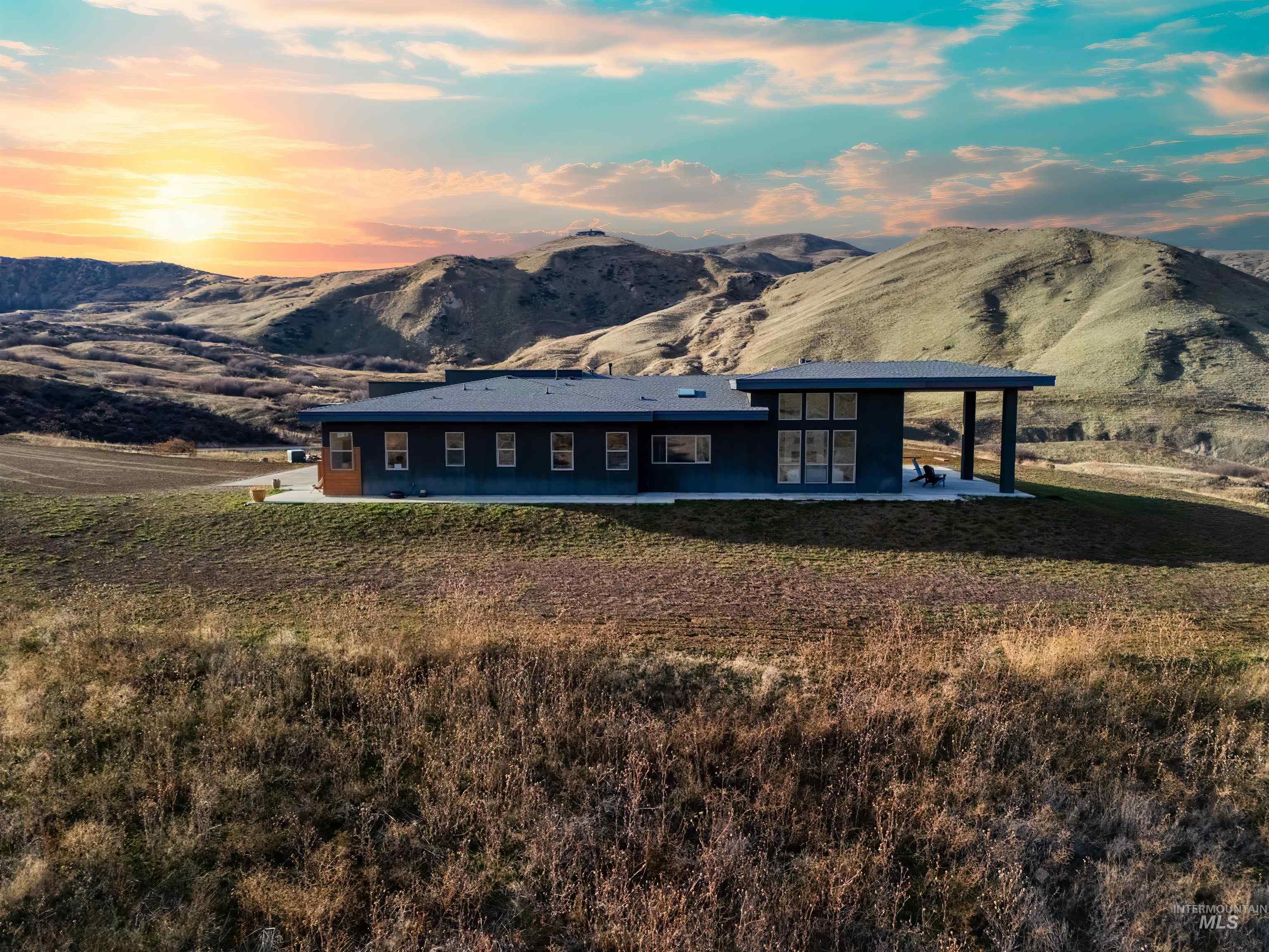 View of front of house with a patio, a mountain view, a lawn, and french doors