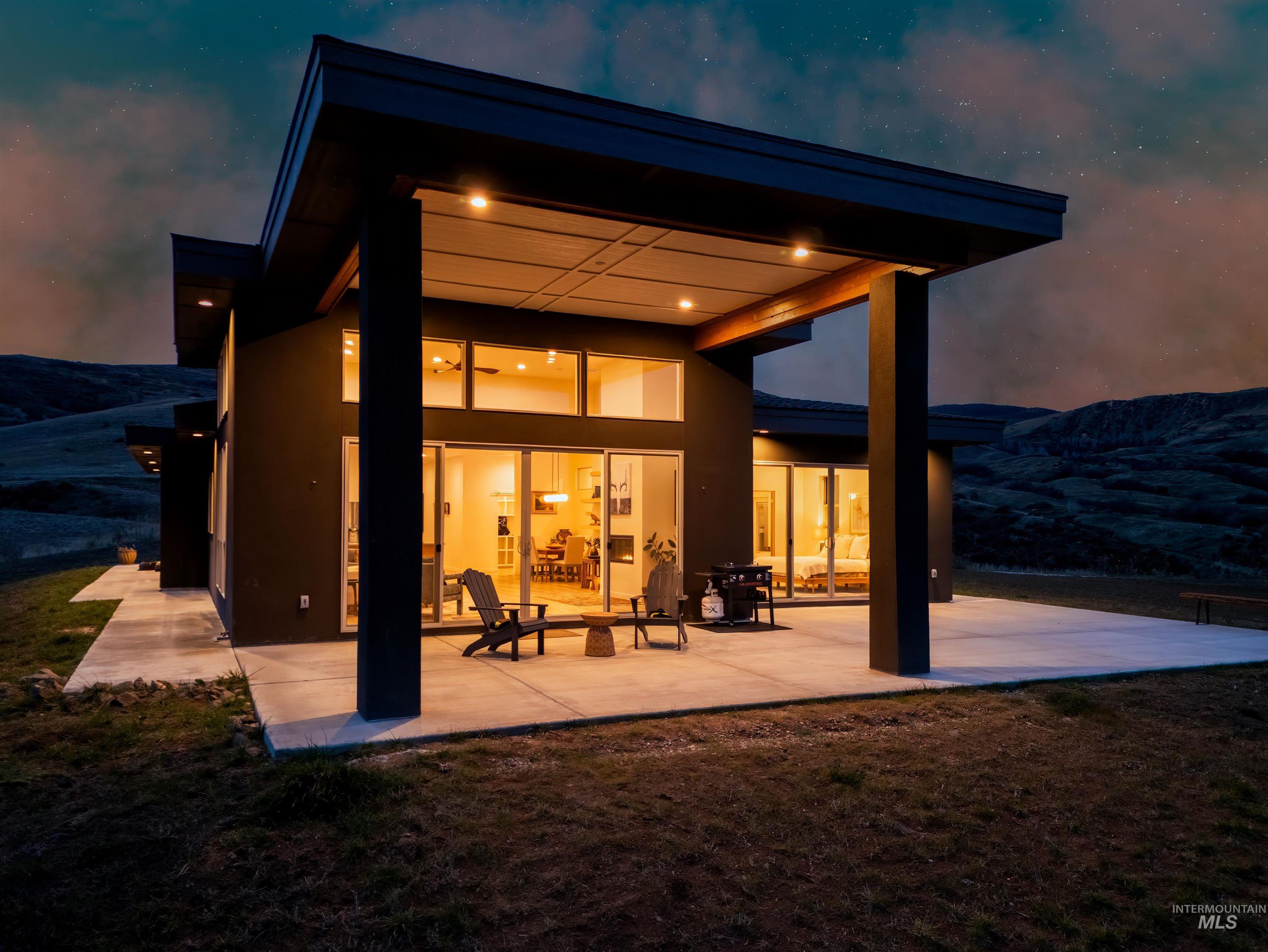 Back of house with a patio, stucco siding, a mountain view, and a yard