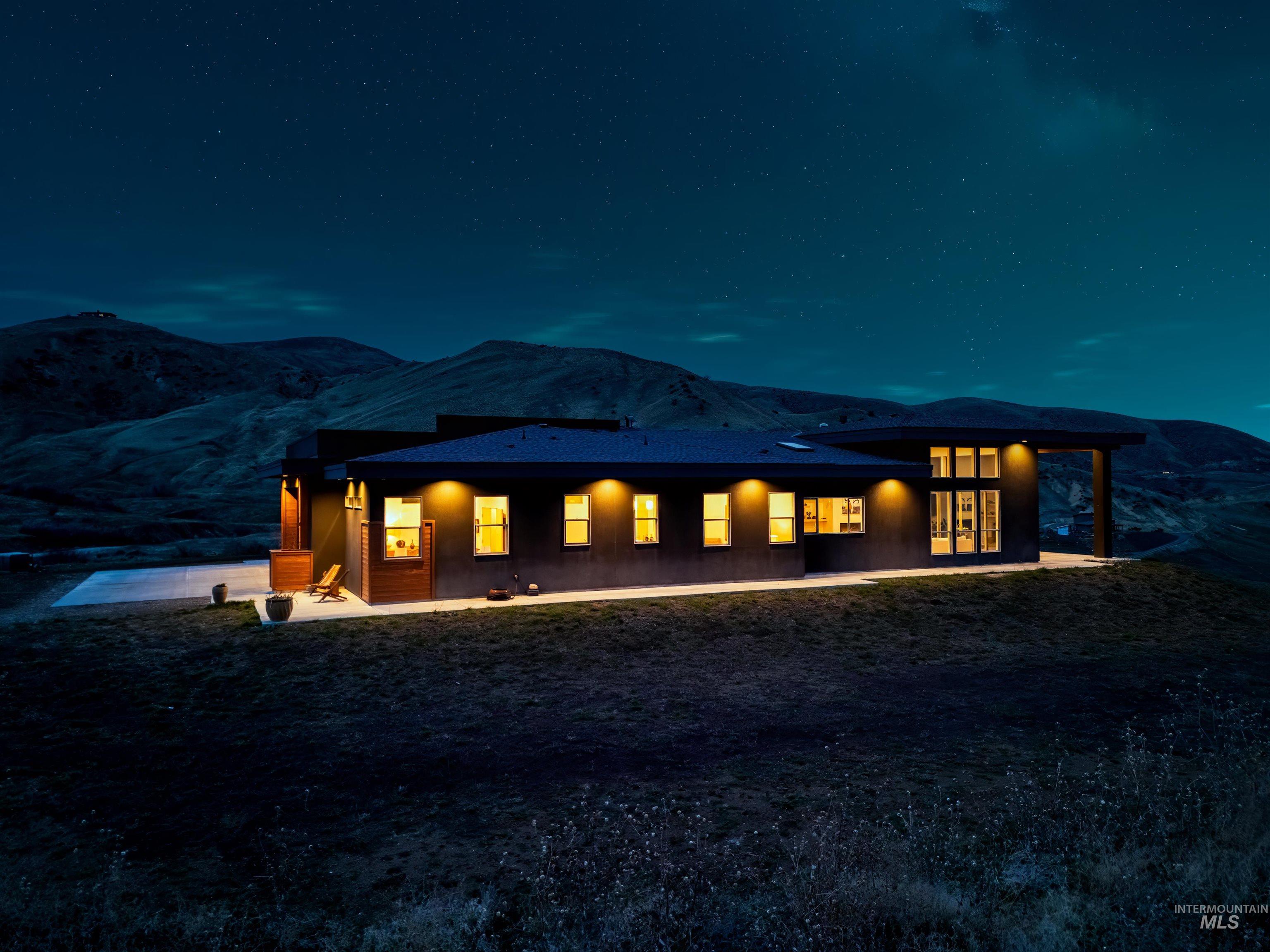Back of house at twilight featuring a patio