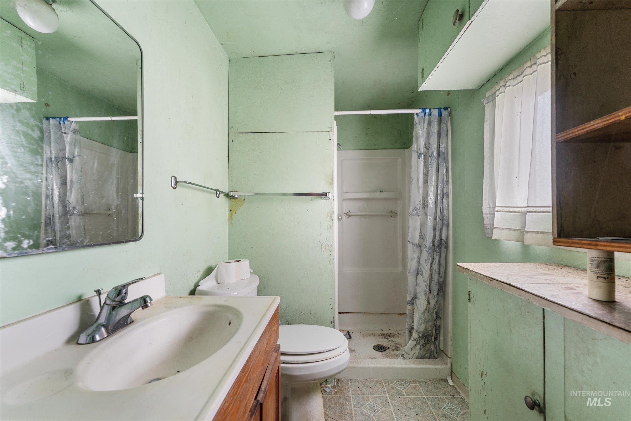 Bathroom with vanity, a stall shower, and light tile patterned floors