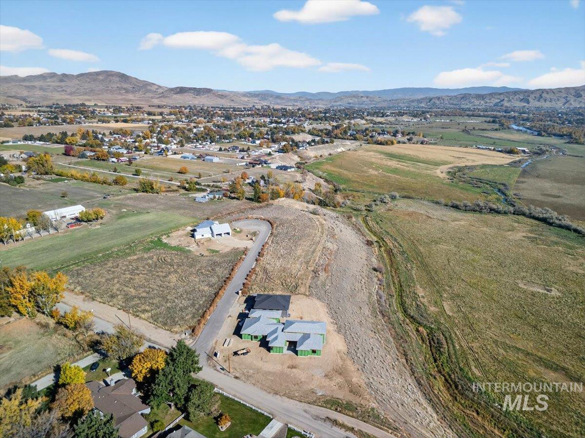 Aerial view of property's location featuring a mountain backdrop and rural landscape