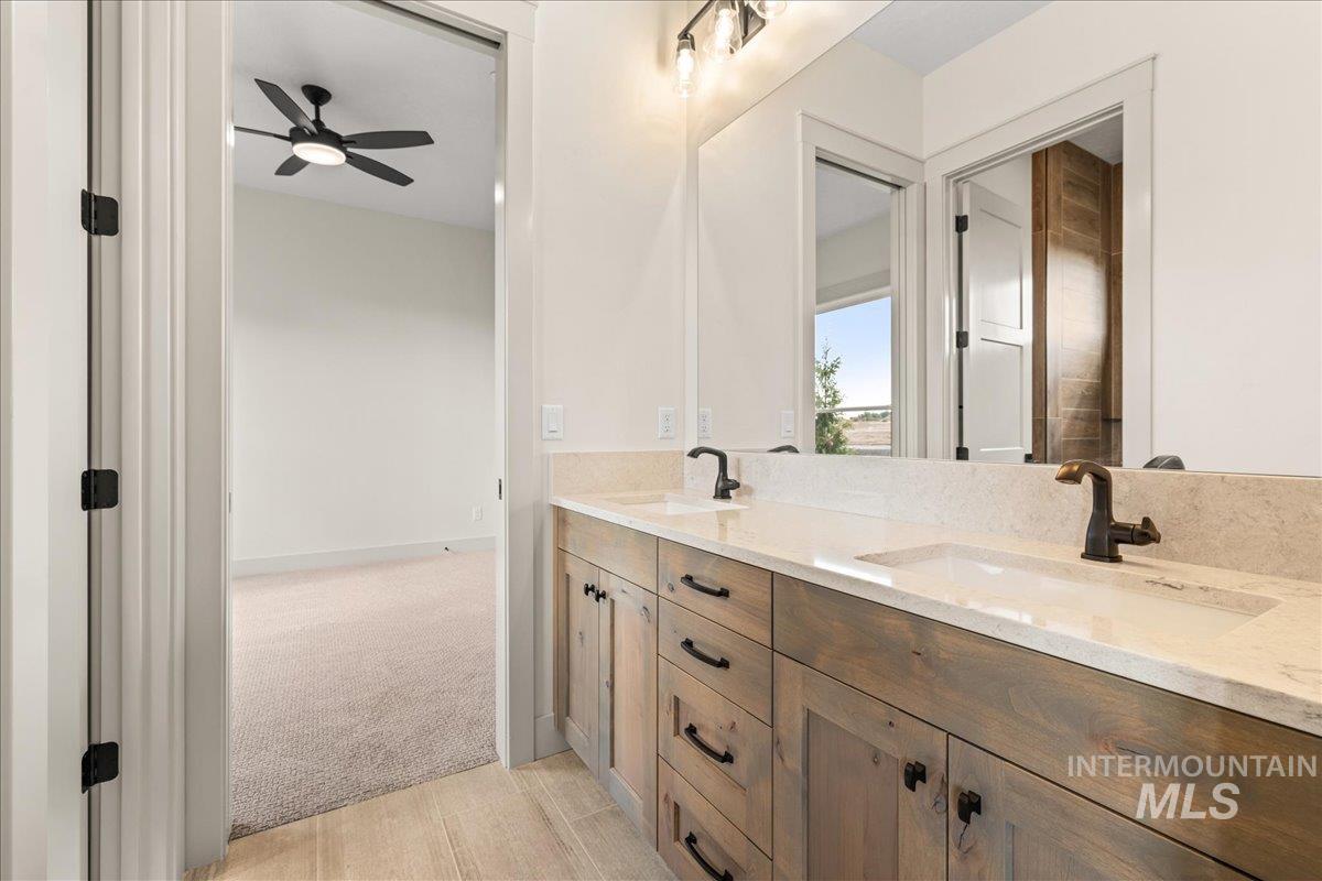 Full bathroom with double vanity and ceiling fan