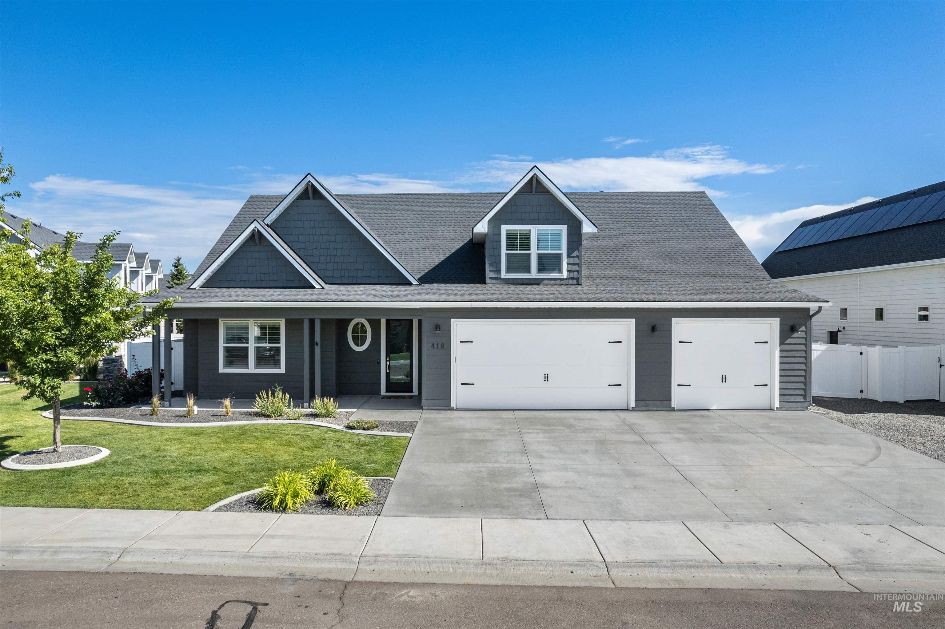 View of front facade featuring driveway, an attached garage, and roof with shingles