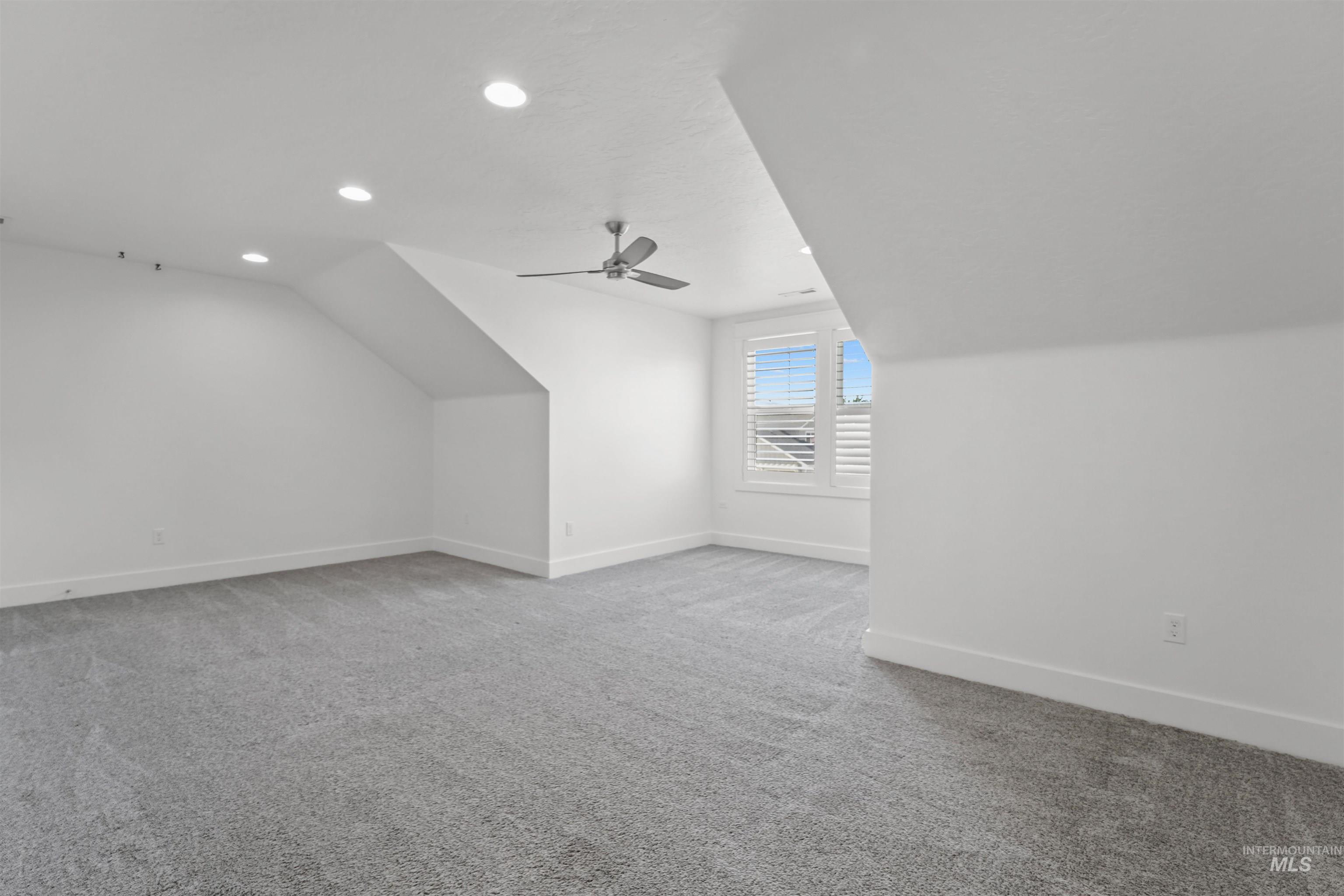 Additional living space featuring vaulted ceiling, carpet, recessed lighting, and ceiling fan