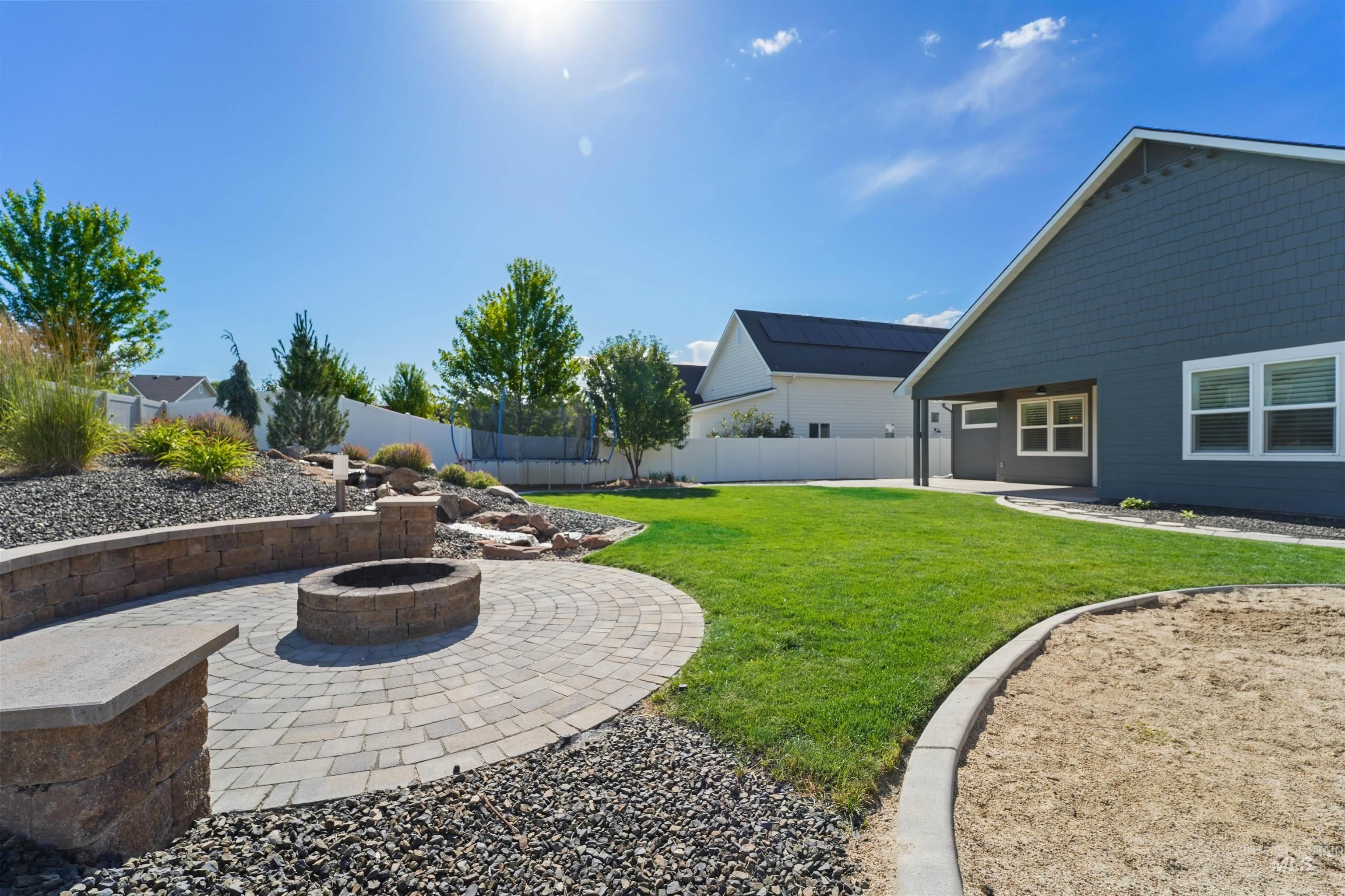 Fenced backyard with a patio and a fire pit