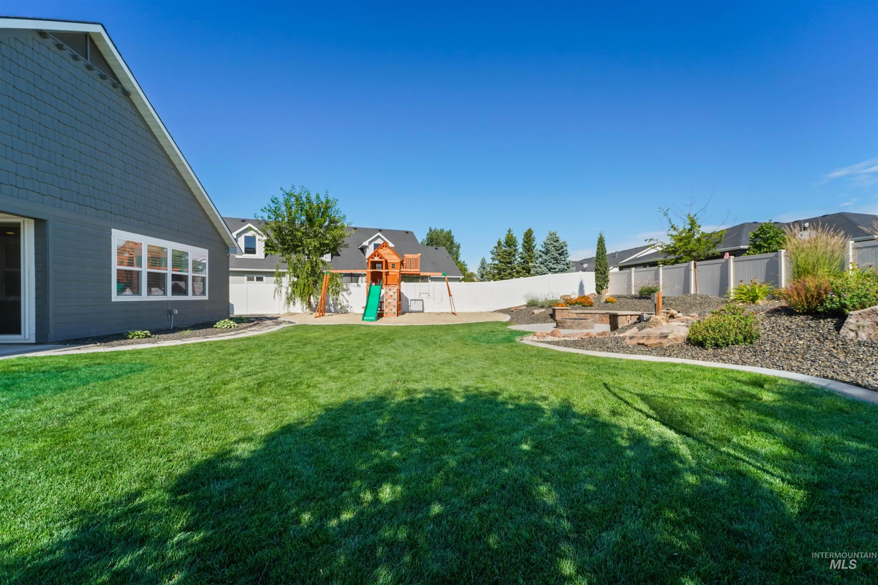 Fenced backyard featuring a playground