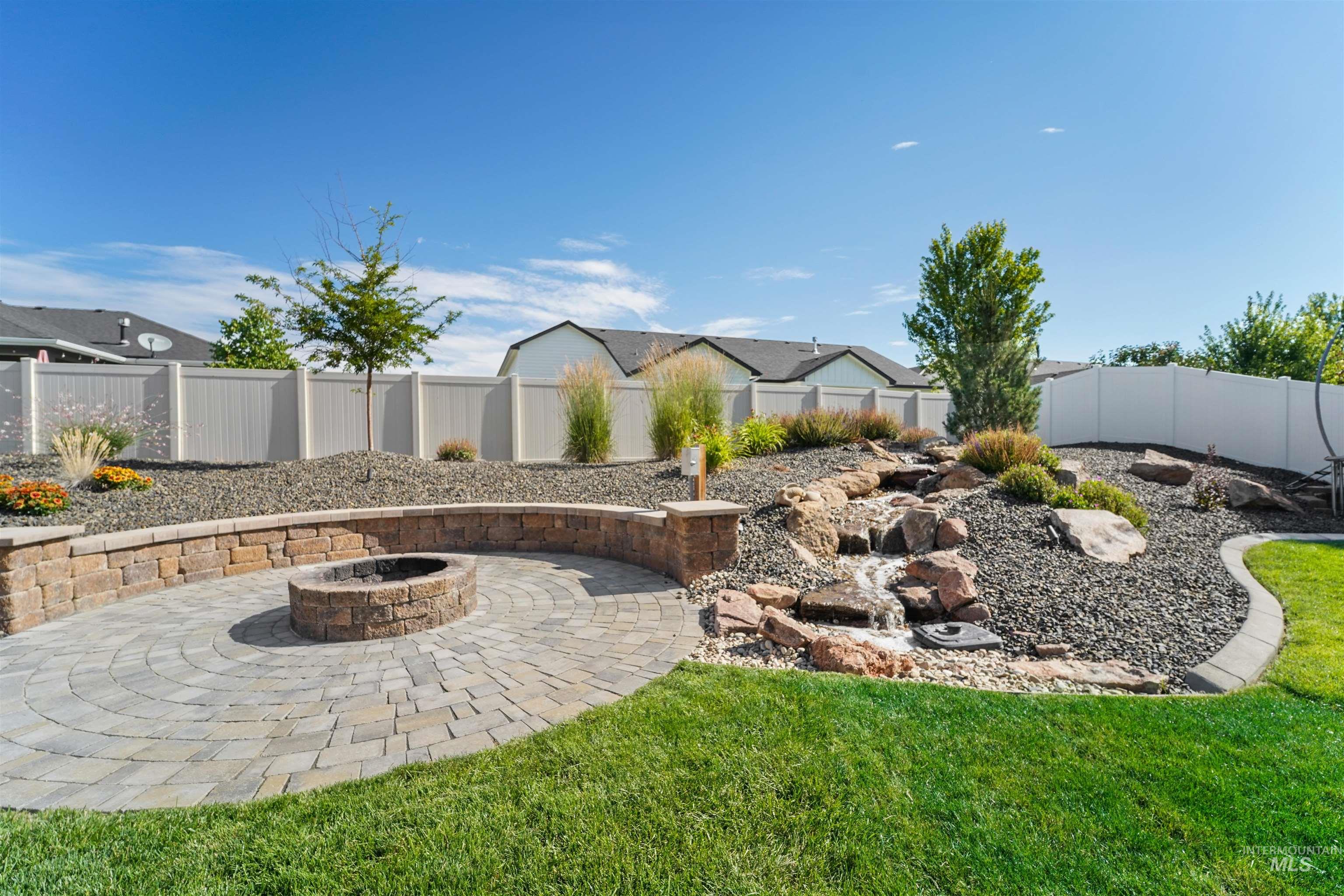 Fenced backyard with a fire pit and a patio area