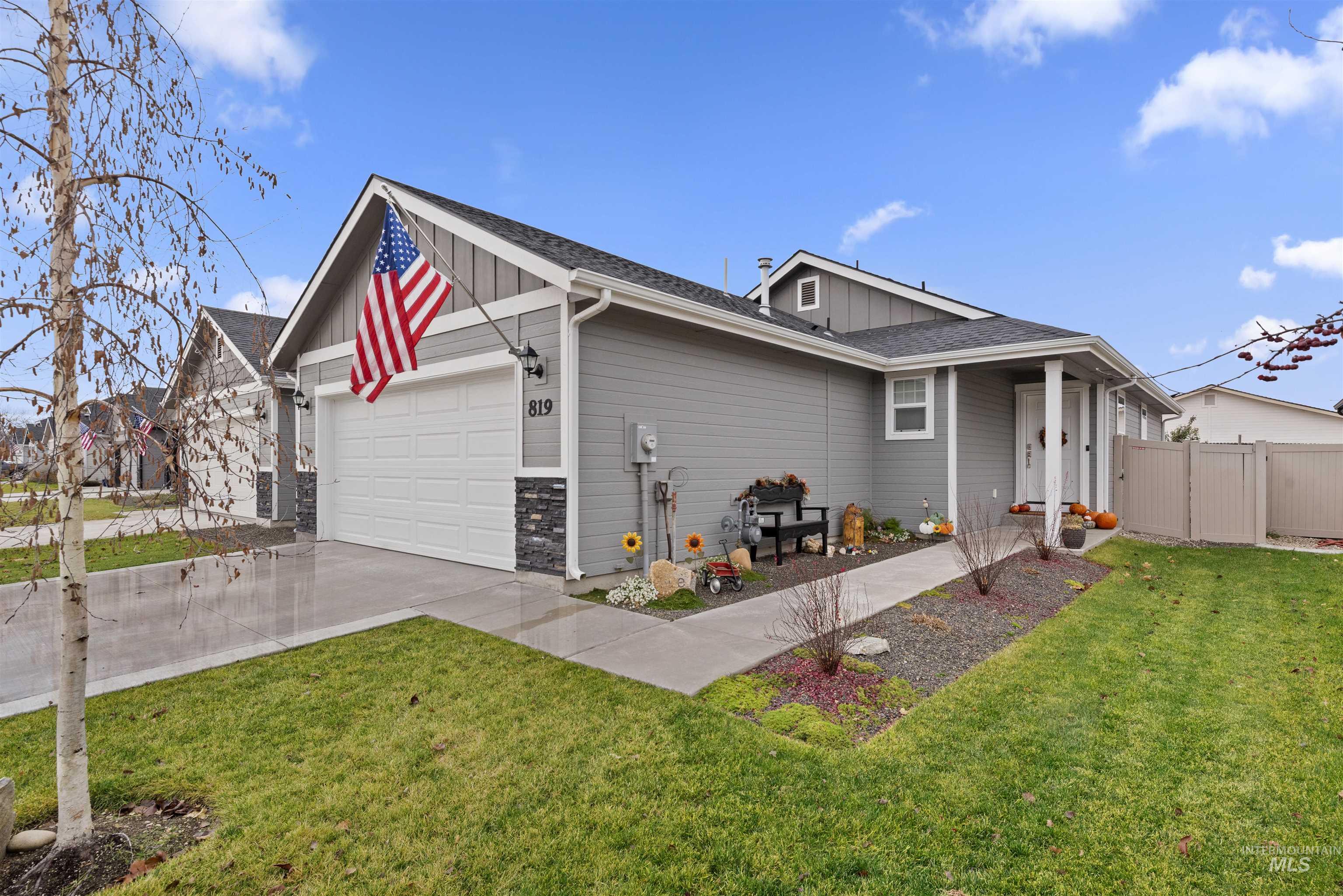 View of home's exterior with board and batten siding, an attached garage, driveway, and roof with shingles