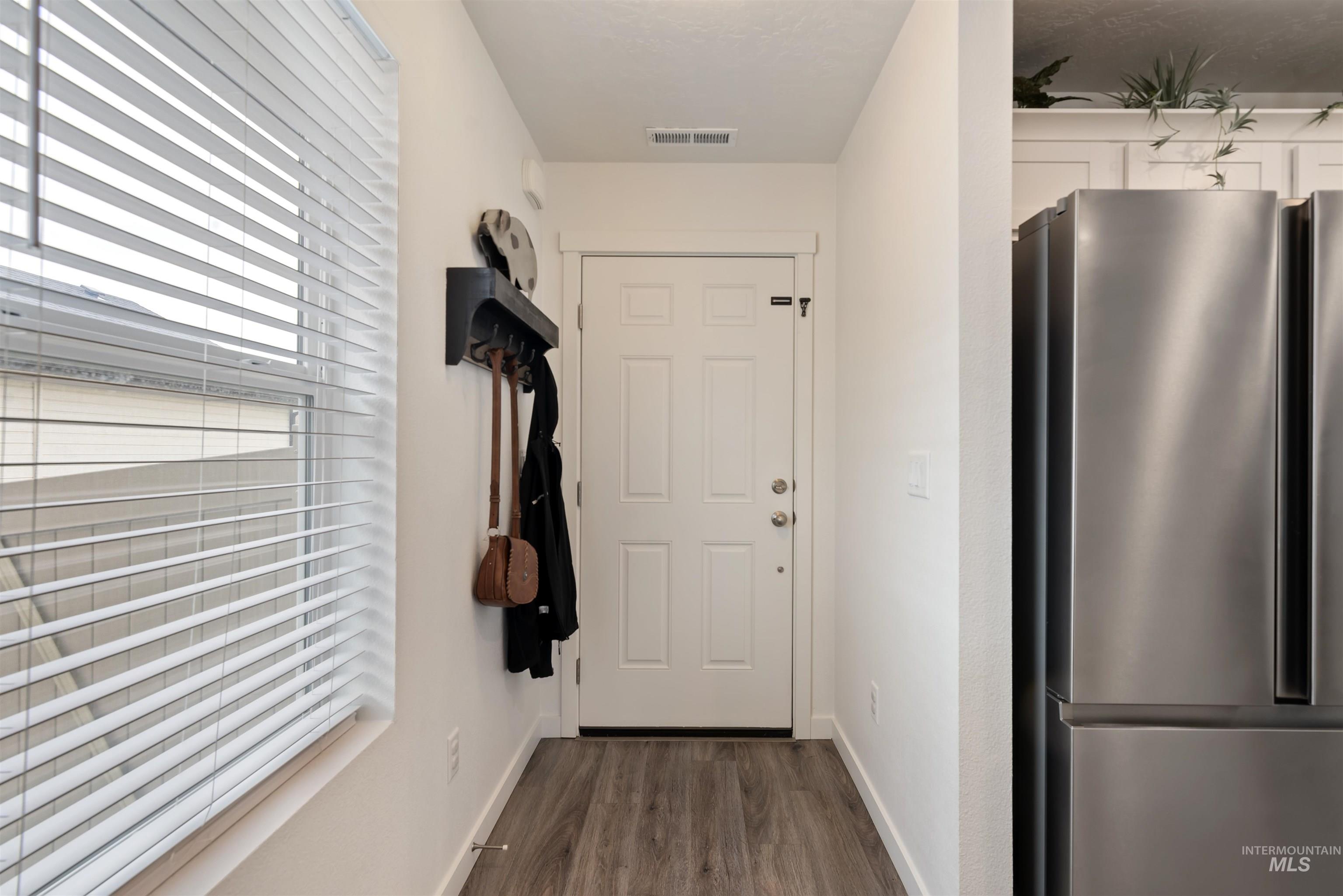 Doorway to outside featuring wood finished floors and baseboards