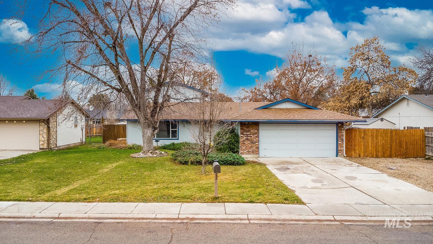 Single story home featuring driveway, brick siding, a garage, and a shingled roof