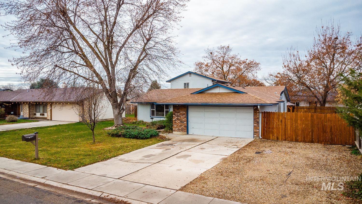 Traditional-style house with concrete driveway, brick siding, an attached garage, and roof with shingles
