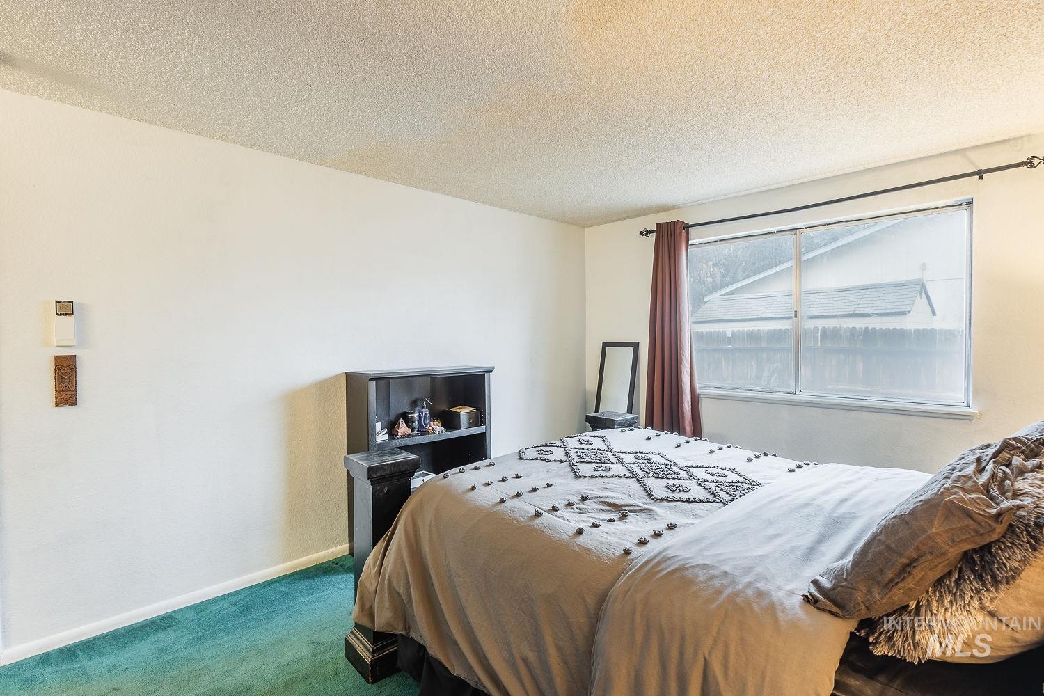 Carpeted bedroom featuring a textured ceiling
