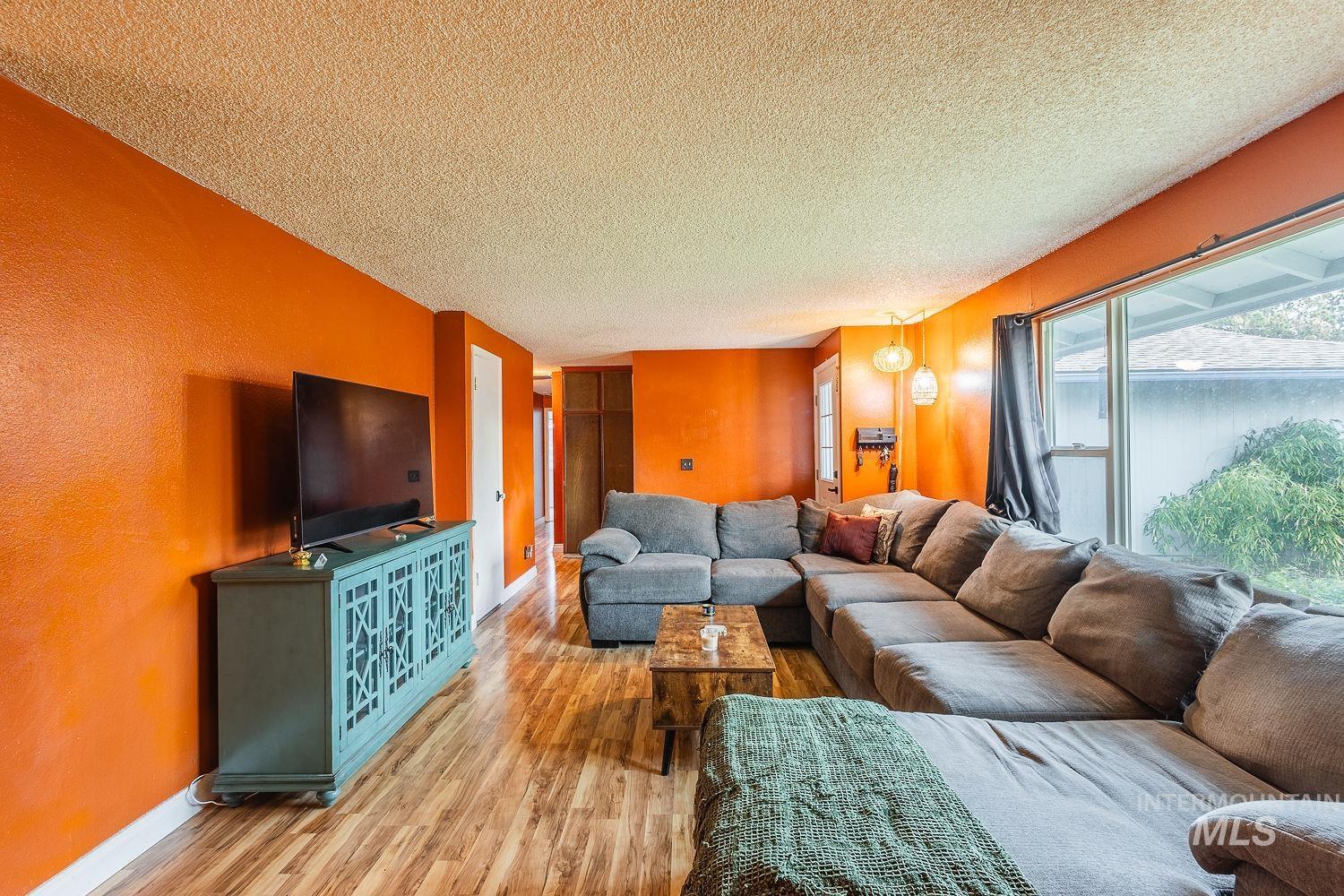 Living room featuring a textured ceiling and wood finished floors