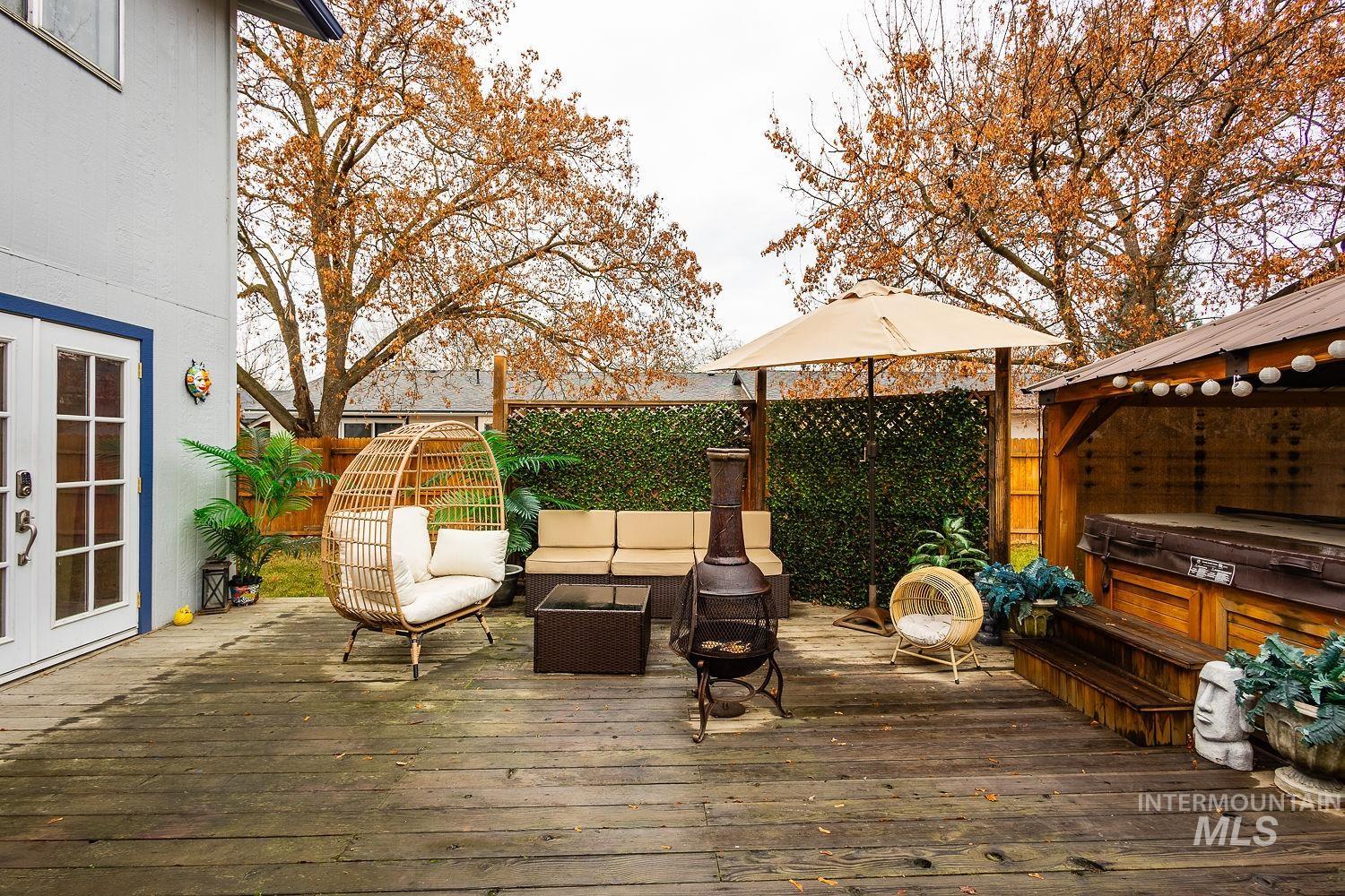 Deck with french doors, a hot tub, an outdoor living space, and a gazebo