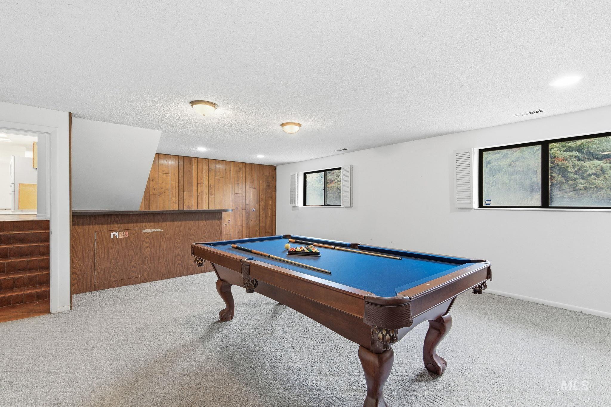 Recreation room featuring wood walls, carpet floors, a textured ceiling, billiards, and recessed lighting