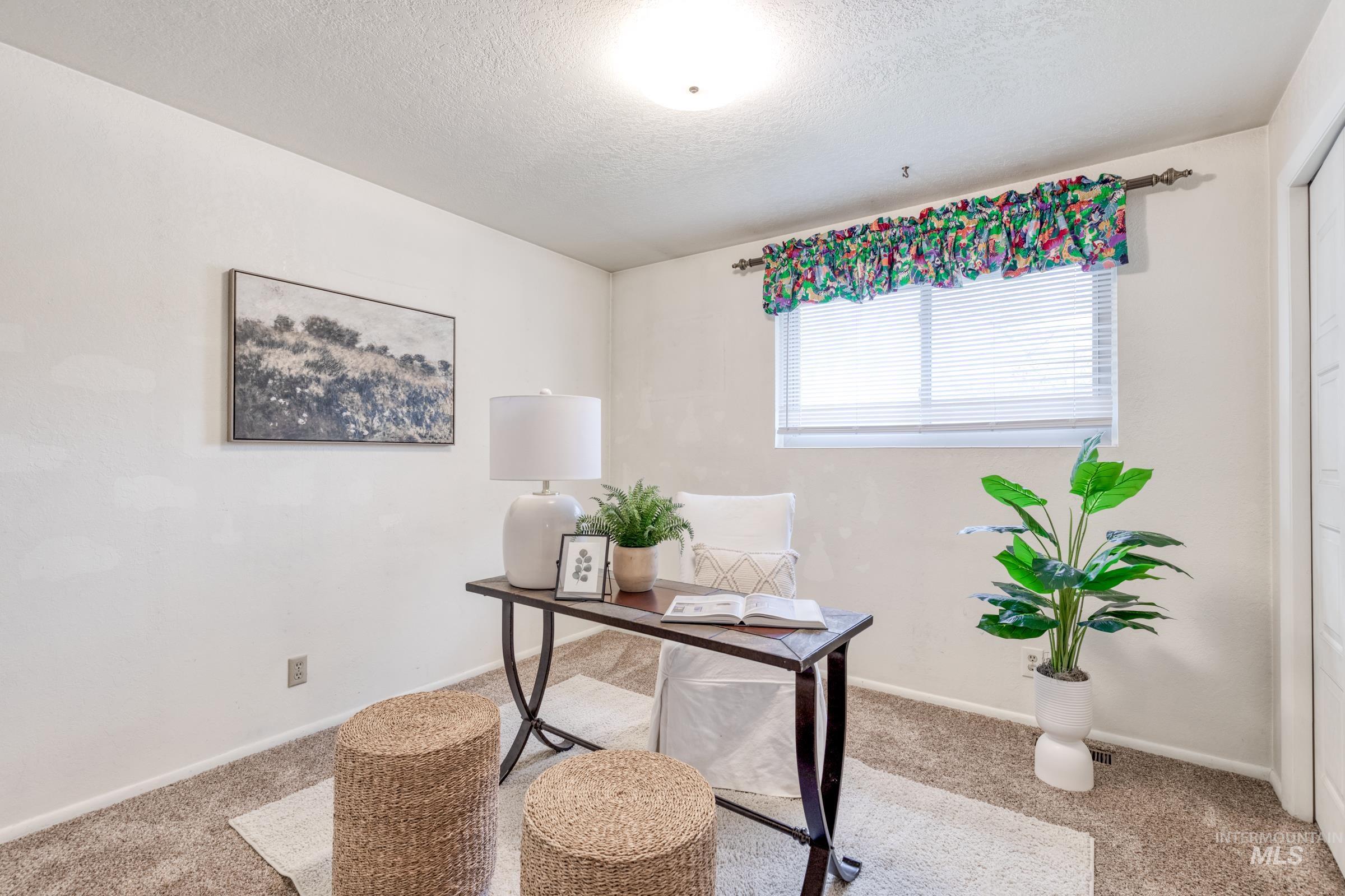 Office area featuring a textured ceiling and carpet floors